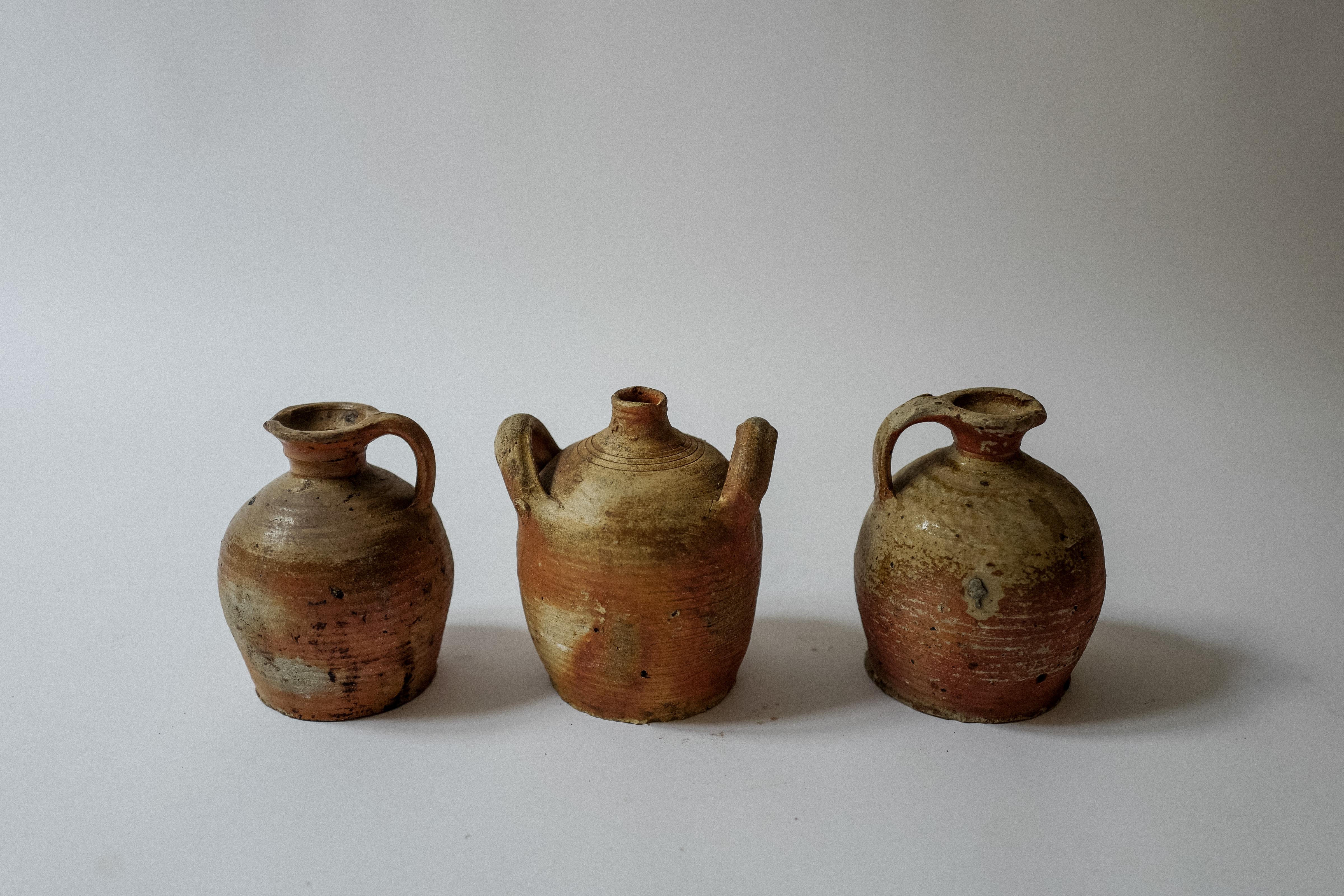 Questo affascinante set di tre brocche per l'acqua in gres della provincia francese risale al XIX secolo e presenta una splendida patina consumata dal tempo. Ogni brocca è realizzata in modo unico e riflette la bellezza rustica e la maestria tipica