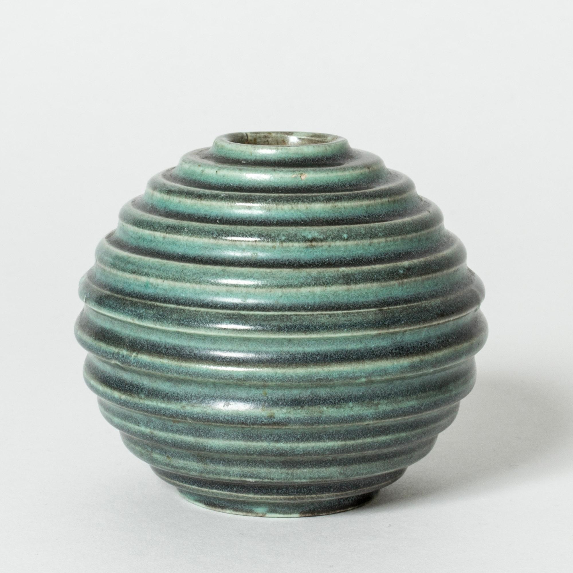 Small stoneware vase by Ewald Dahlskog, in a globe form with embossed stripes. Glazed green with black streaks. This signature design by Dahlskog was first introduced at the Stockholm Exhibition in 1930.