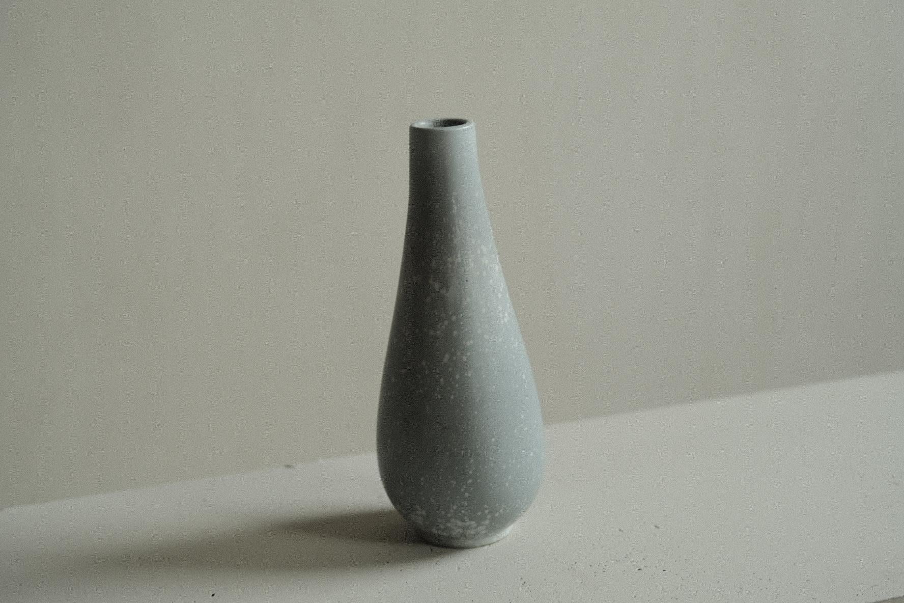 Stoneware vase in a clean form by Gunnar Nylund, the undulating rim softens the form. Light blue glaze.

Signed underneath. 

Gunnar Nylund was one of the most influential ceramicists and designers of the Swedish mid-century period. Nylund worked