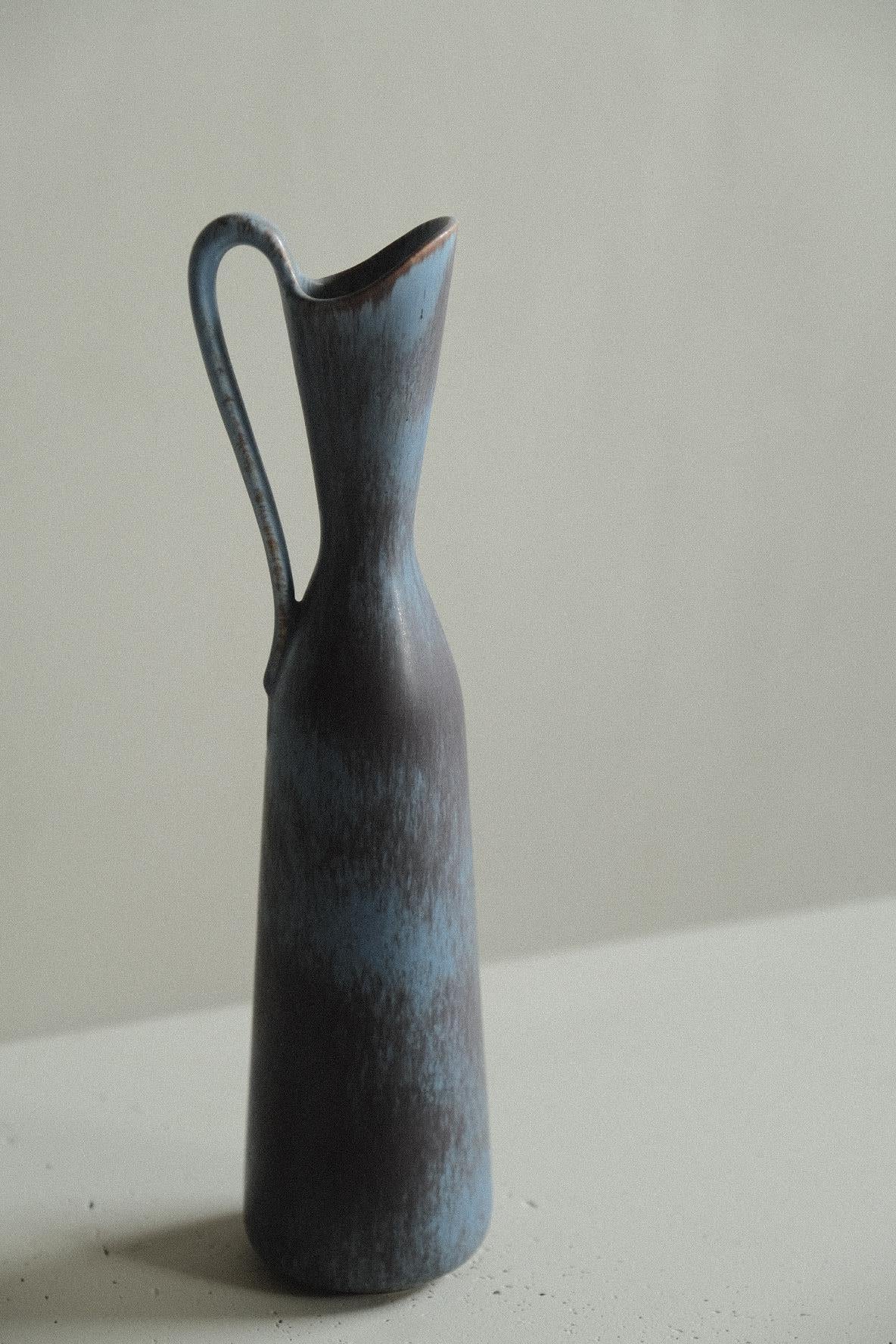 Stoneware vase in a clean form by Gunnar Nylund, model AVE for Rörstrand. In a blue and brown hare´s fur glaze.

Signed underneath. 

Gunnar Nylund was one of the most influential ceramicists and designers of the Swedish mid-century period.