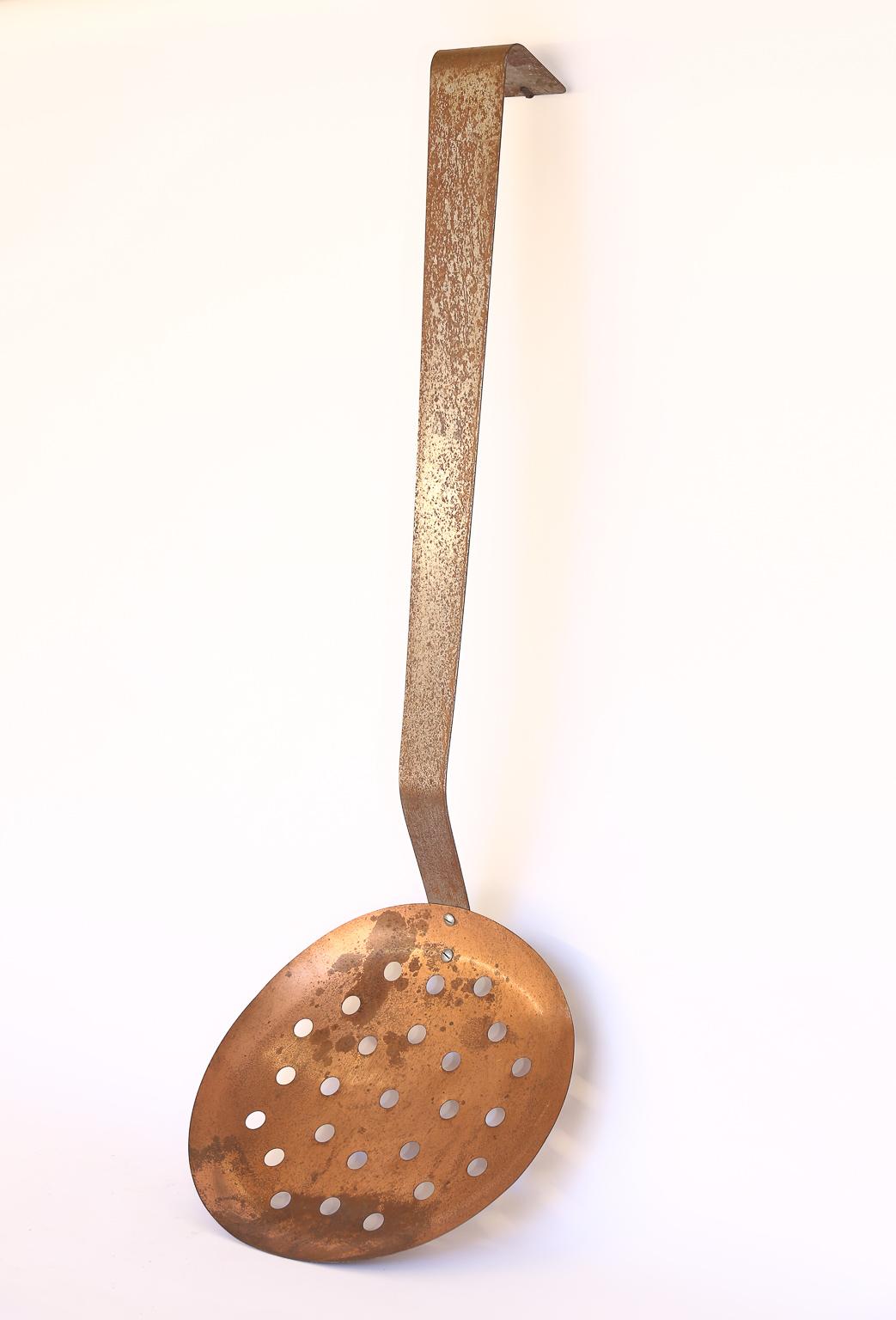 This is a large slotted spoon once used as a store display piece for a kitchen shop. This would be a wonderful conversation piece for your kitchen or breakfast room. Hanging in the upright position the slotted spoon measures 52