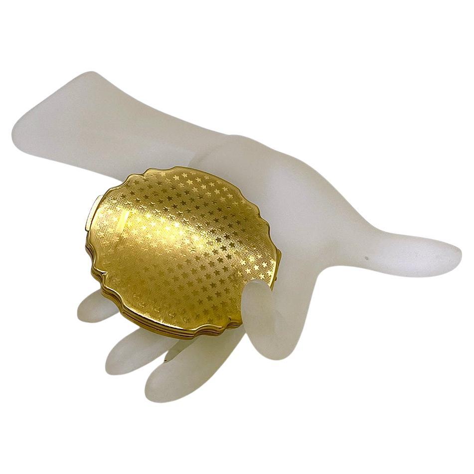 Il s'agit d'un compact vintage Stratton en nacre. Nous sommes ravis de trouver ce compact anglais en très bon état, avec 60 ans de vie ! Il est de petite taille avec un bord festonné et le dessus est orné de carreaux de nacre. Au dos, il porte le