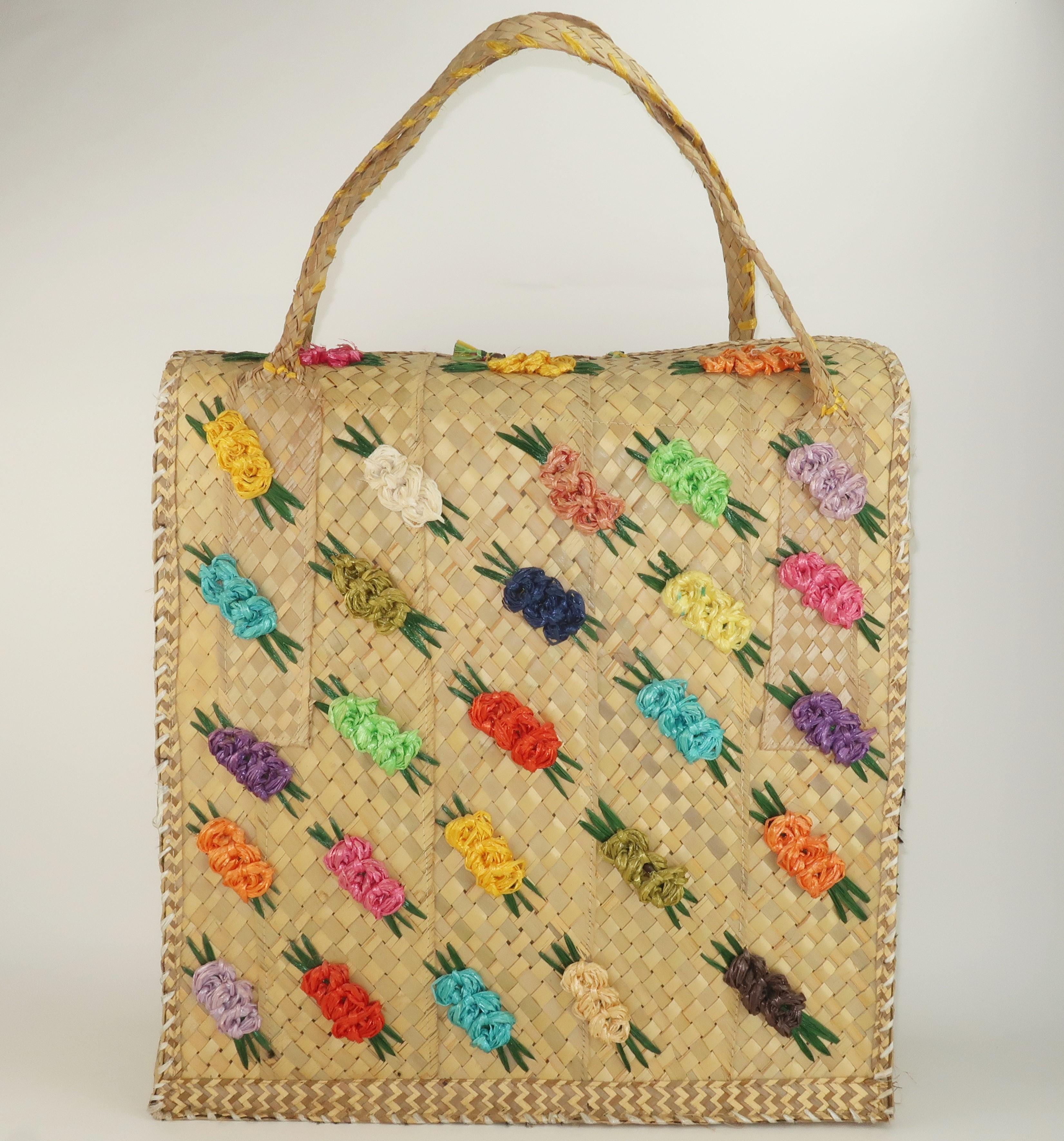 Get ready for a day at the beach with a colorful vintage straw bag in an extra large size perfect for toting towels, snacks and sunscreen!  This vintage bag has a suitcase shape with raffia floret decorations in shades of green, pink, blue, yellow,