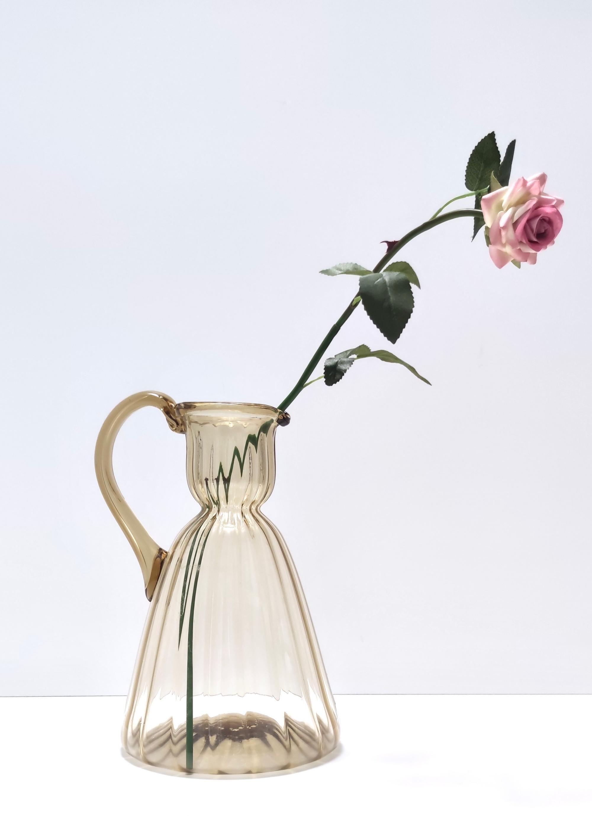 Made in Italy, 1920s.
This pitcher vase is made in straw-colored glass. 
It is a vintage piece, therefore it might show slight traces of use, but it can be considered as in perfect original condition and ready to become a piece in a home.