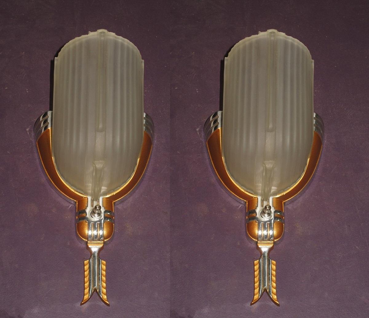 Priced for the pair.
You can clearly see the design influence of the 1920s and 1930 Streamline Steam Locomotives in these wonderful Art Deco wall sconces. With a hint of Southwest flair with the feather bottom finial, the cross hath pattern around