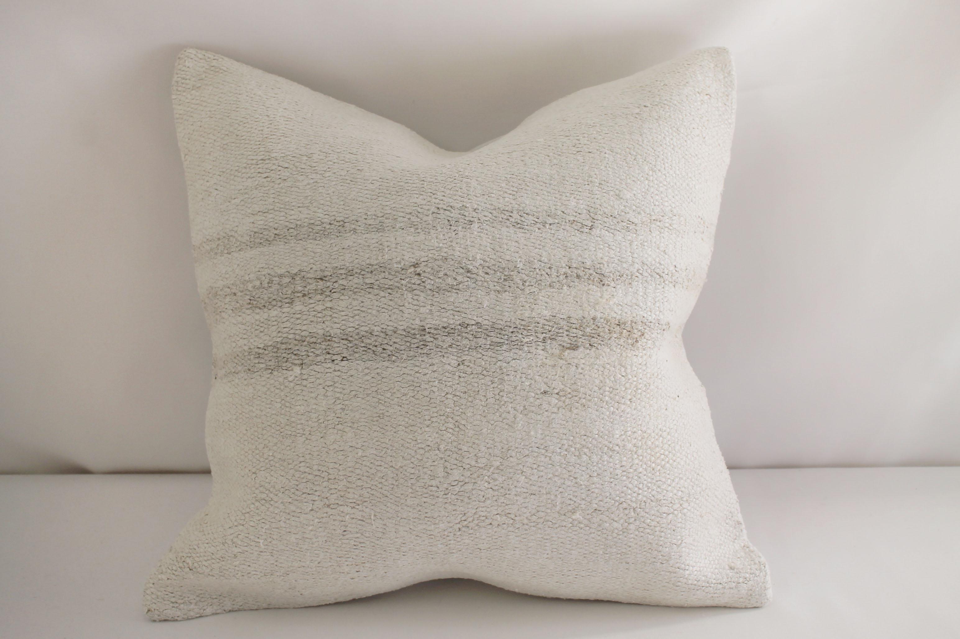 Vintage Turkish hemp rug pillow in off-white, light natural color with woven stripes on the face of the pillow. Beautiful original hemp rug, this portion has slightly darker natural stripes, backside is a coordinating fabric with zipper closure. No