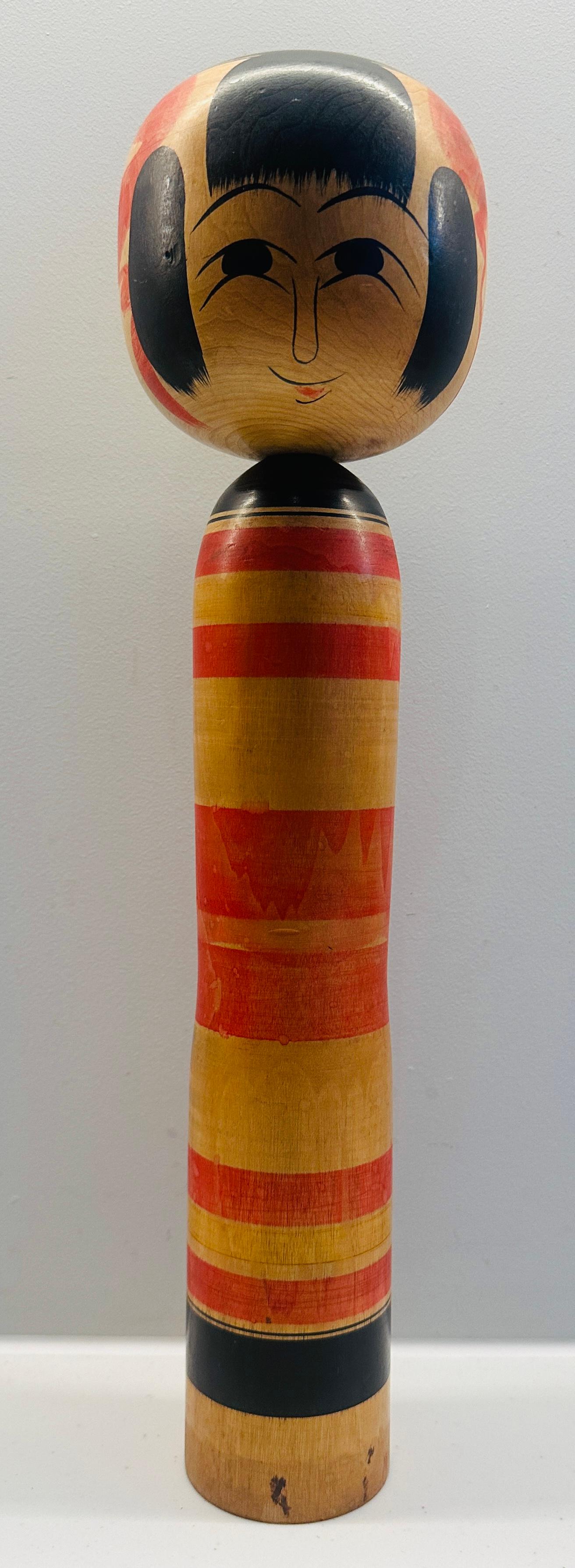A beautifully painted with a joyful face vintage striped Japanese traditional Kokeshi Doll which I've identified from Yajirou-Kei but happy to stand corrected.  The majority of this style are brightly painted utilising a rainbow of colours, from the