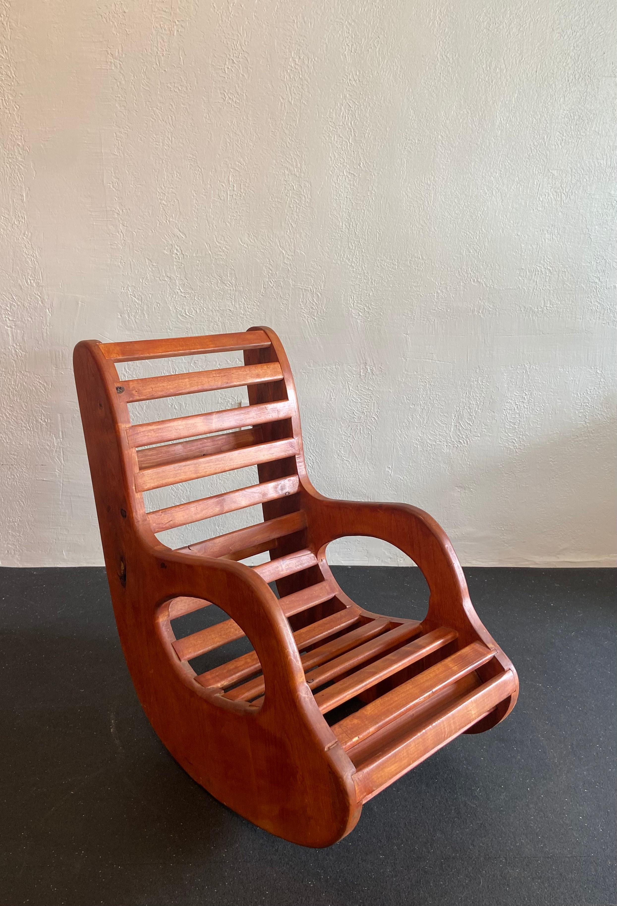 Studio craft organic form rocking chair executed in pine. Exposed knots found throughout. Excellent candidate for a new finish. 

Would work well in a variety of interiors such as modern, mid century modern, Hollywood regency, etc. Piece blends