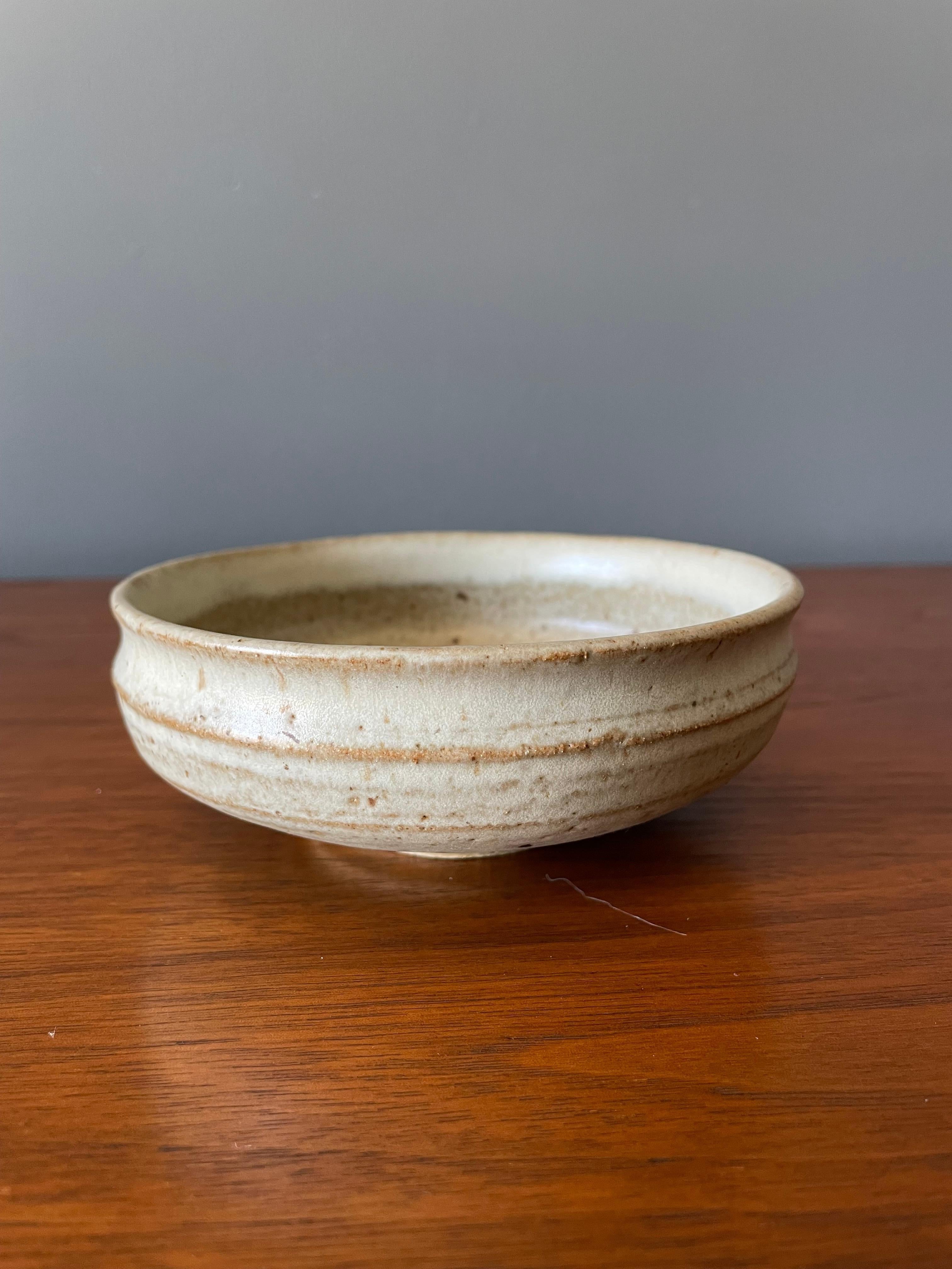 Vintage studio crafted ceramic coffee mug. Circa 1970s. Signed by the artist. Sleek and simple design with a beautiful speckled glazing pattern.
