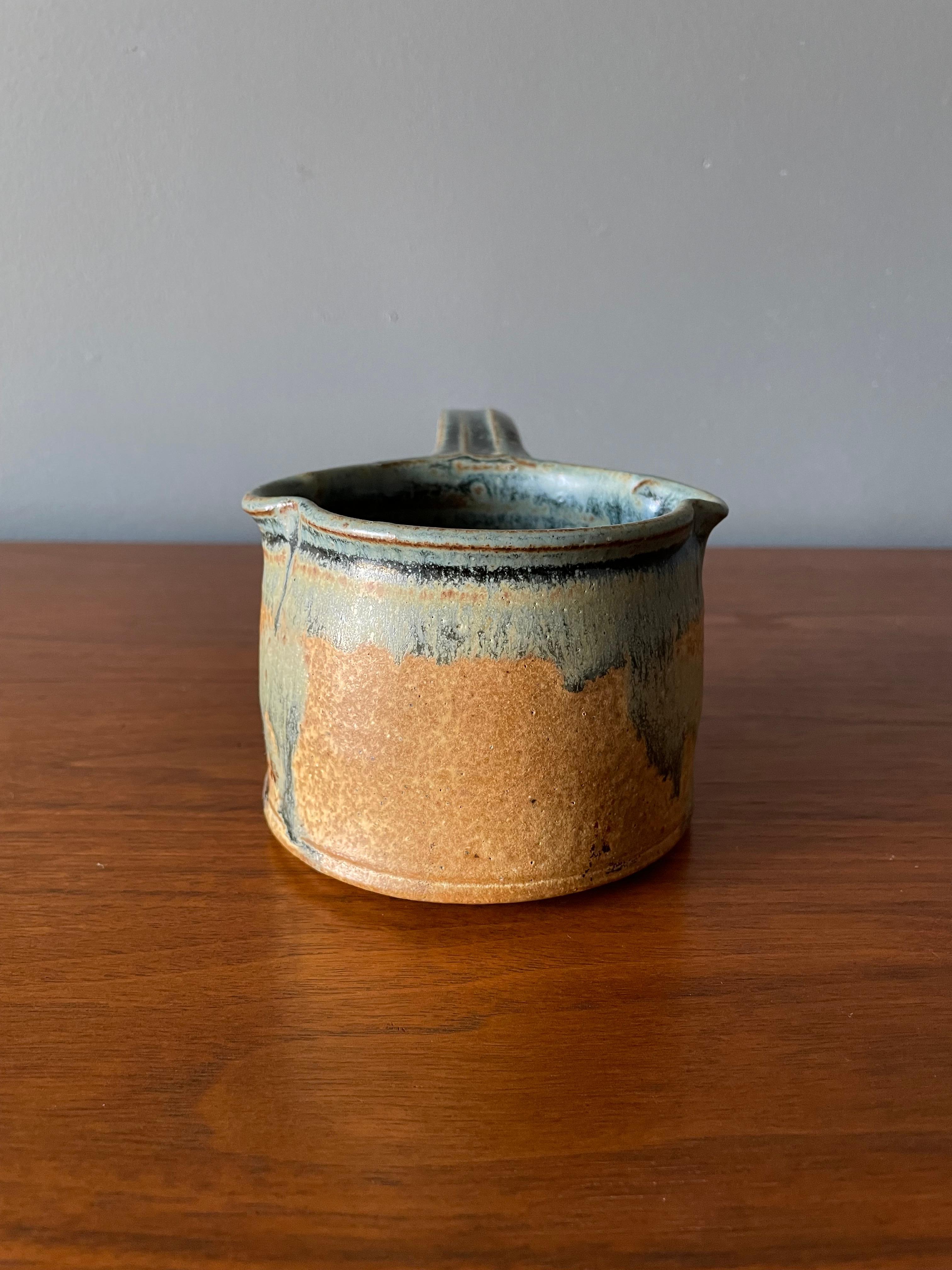 Vintage studio crafted pottery with handle. Beautifully crafted with a unique glazing.