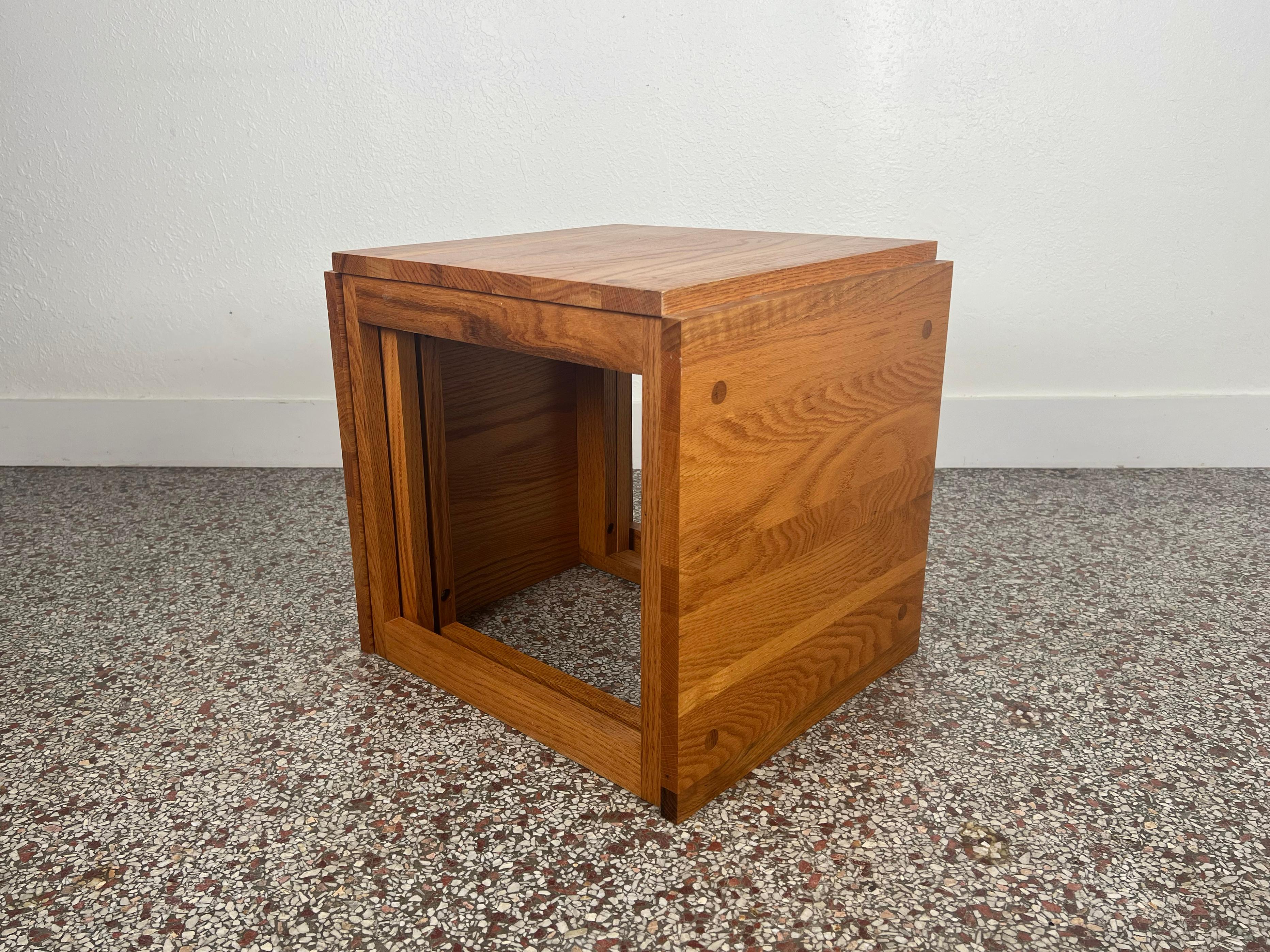Vintage set of three studio crafted nesting tables crafted in solid oak with mortise and tenon detailing on surfaces. Tables fit together to form one singular cube. 

Origin: USA

Year: 1970s

Dimensions: 19