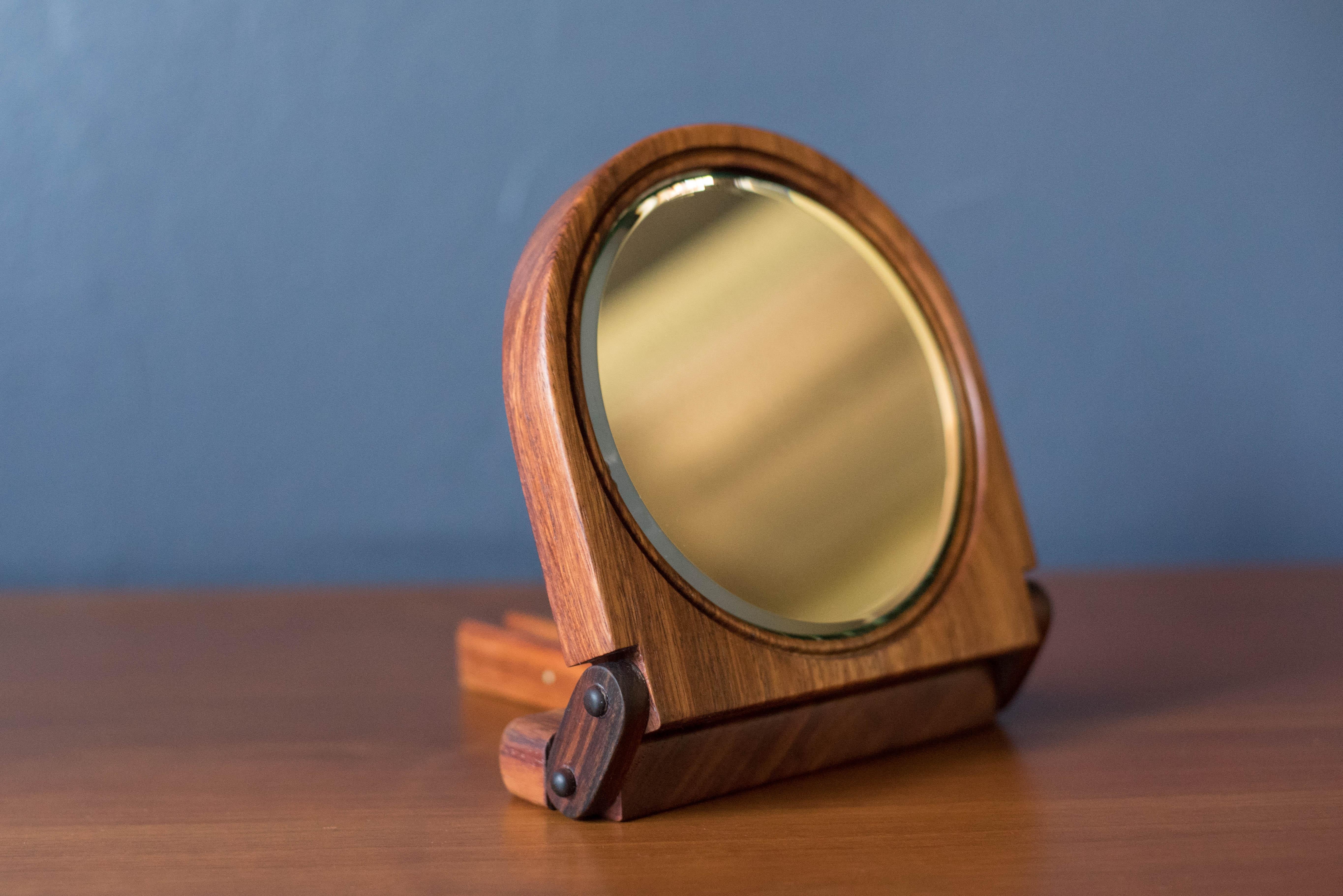 Mid century round foldable mirror with adjustable stand in koa wood. This versatile hand crafted piece is compact in size and can used as a table or small vanity mirror. 

Mirror 5