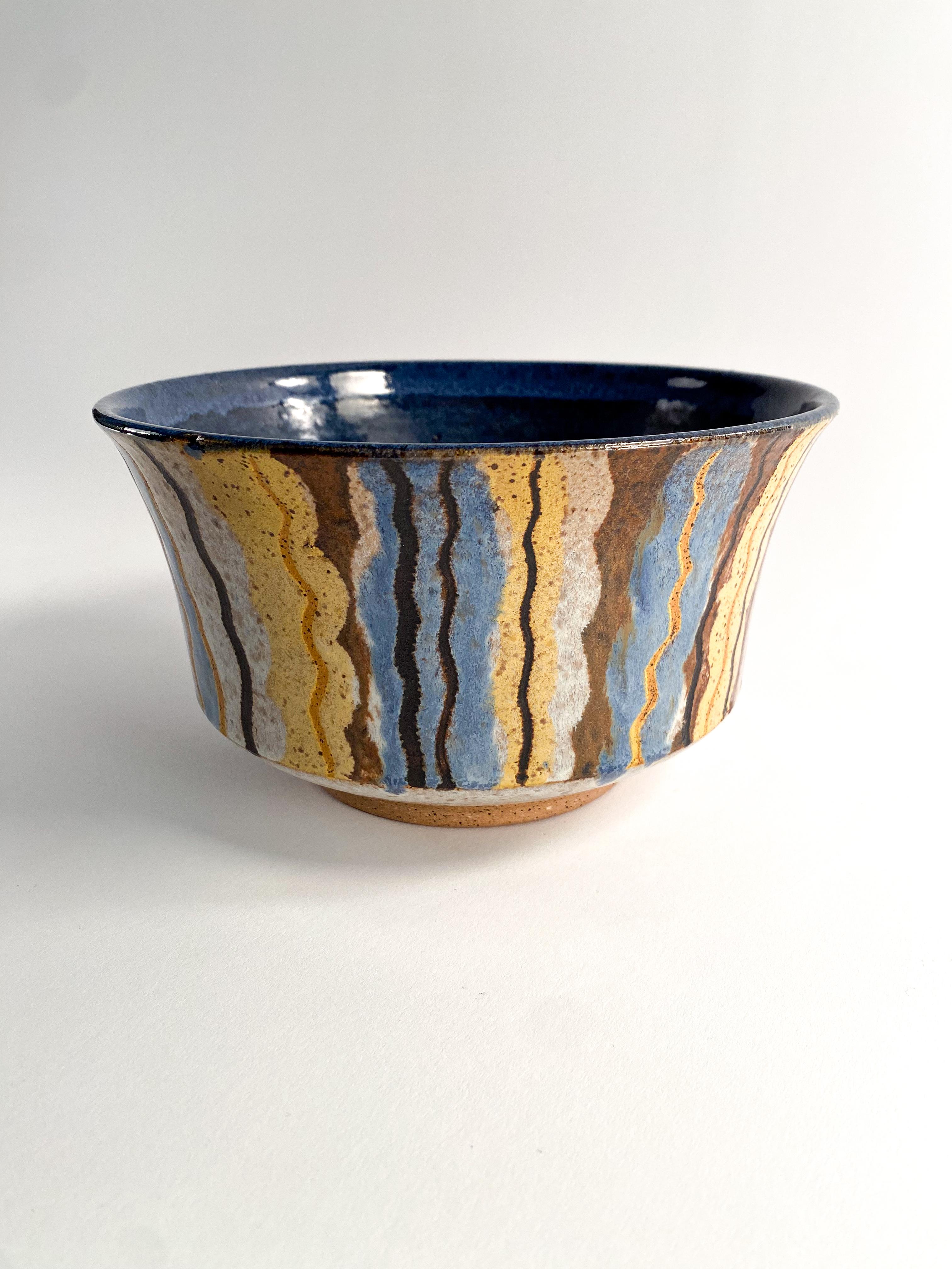 Beautiful vertically striped glaze bowl. signed by artist on the bottom. 