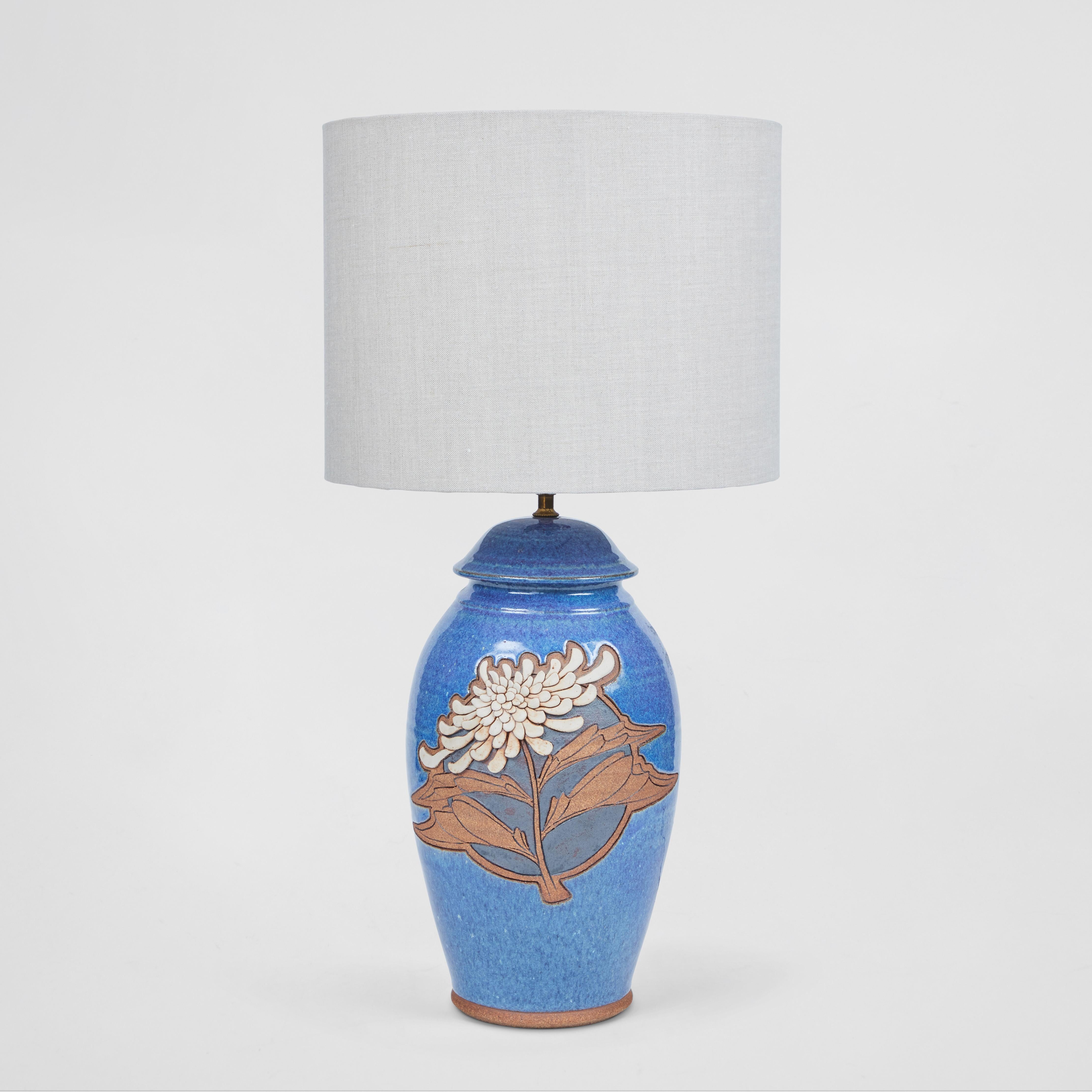 This is an easy way to add a little color to your room. We love this vintage studio pottery lamp with a gorgeous shade of blue glaze and intricate dimensional chrysanthemum flower design. It has been newly rewired, has a new custom linen shade and