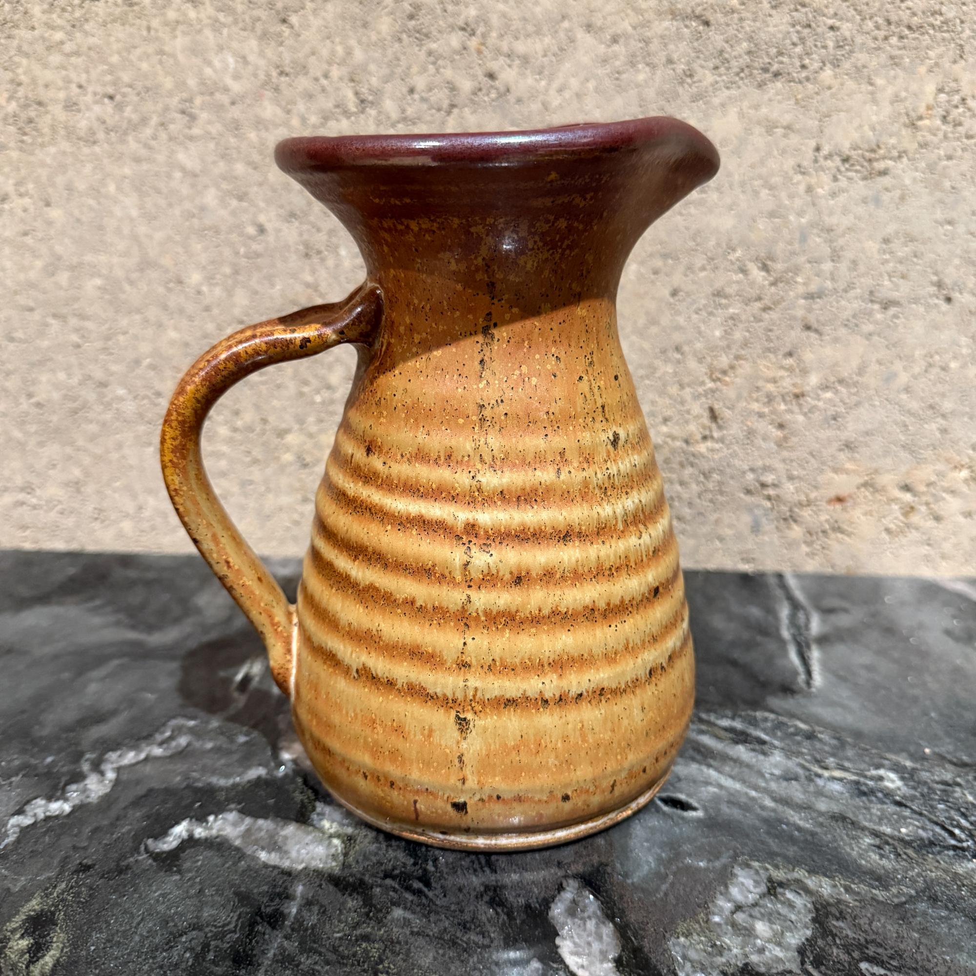 For your consideration, This is a vintage studio pottery pitcher. It is a handcrafted ceramic piece, often with a rustic or farmhouse style, and features a pinched spout. No signature from the maker. Marking s 