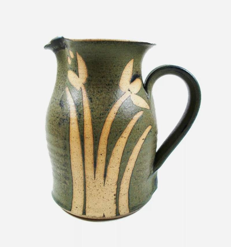 Vintage Krug aus Studio-Töpferware - Blumendekoration aus Wachsresist - gesprenkelte olivgrüne Glasur auf dem Tonkörper - kontrastierende weiße Glasur auf der Innenseite - Chiffre/Initialen des Künstlers an der Basis des Henkels - Mitte