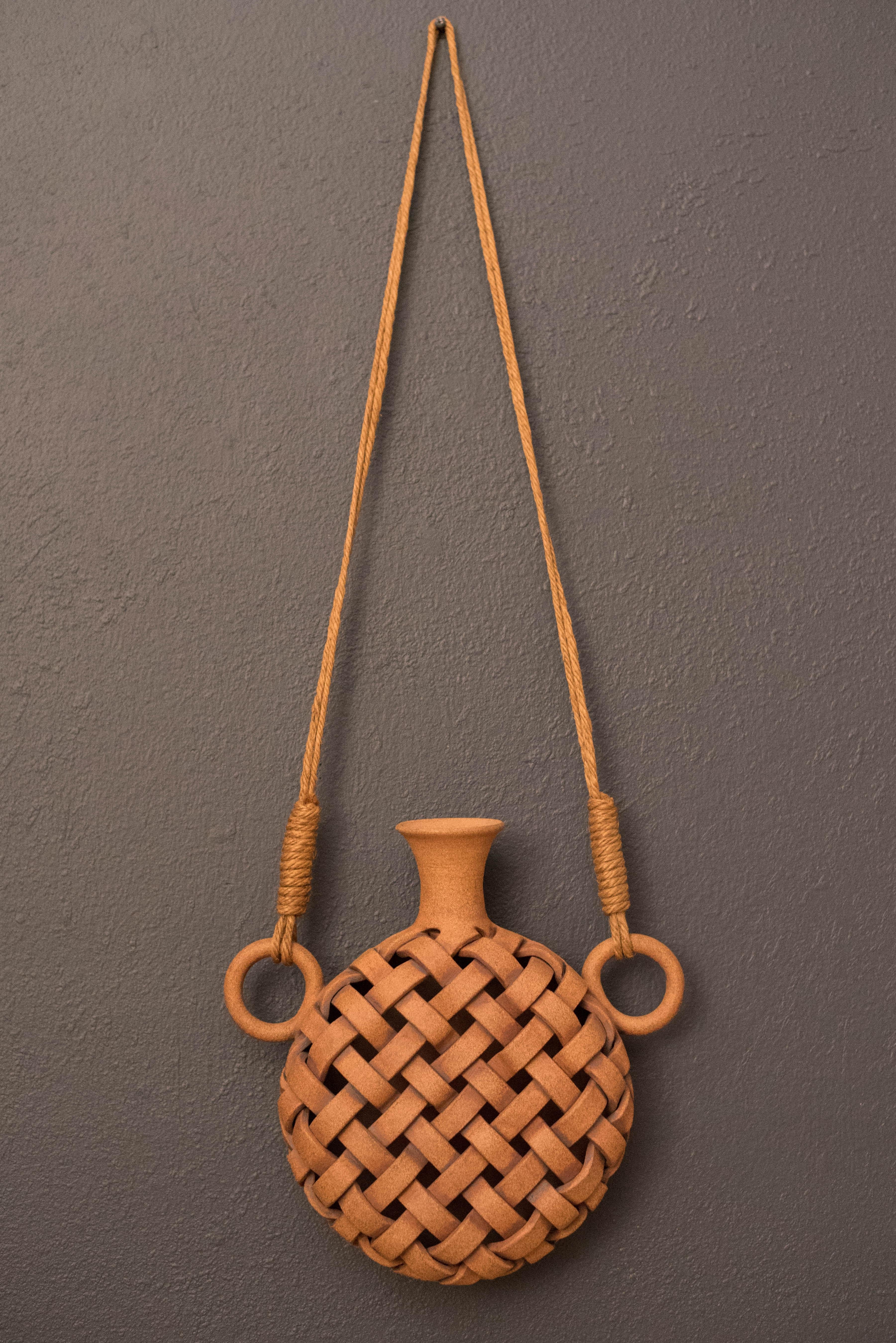 Vintage studio pottery crafted by ceramic artist Joan Jockwig Pearson Watkins circa 1970's. This unique sculpture depicts an original canteen water jug made out of a clay medium with a timeless lattice design. Includes a wall hanging rope adding a