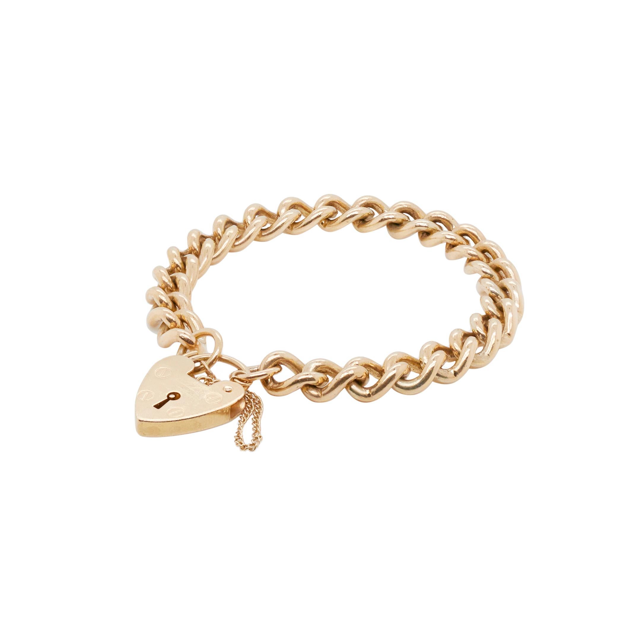 Dieses wunderschöne Panzergliederarmband versprüht Vintage-Charme. Das Stück besteht aus massiven, ineinandergreifenden Gliedern aus 9 Karat Gelbgold. Sein Herzstück ist ein romantisches, herzförmiges Vorhängeschloss, das die Kette sichert. Es dient