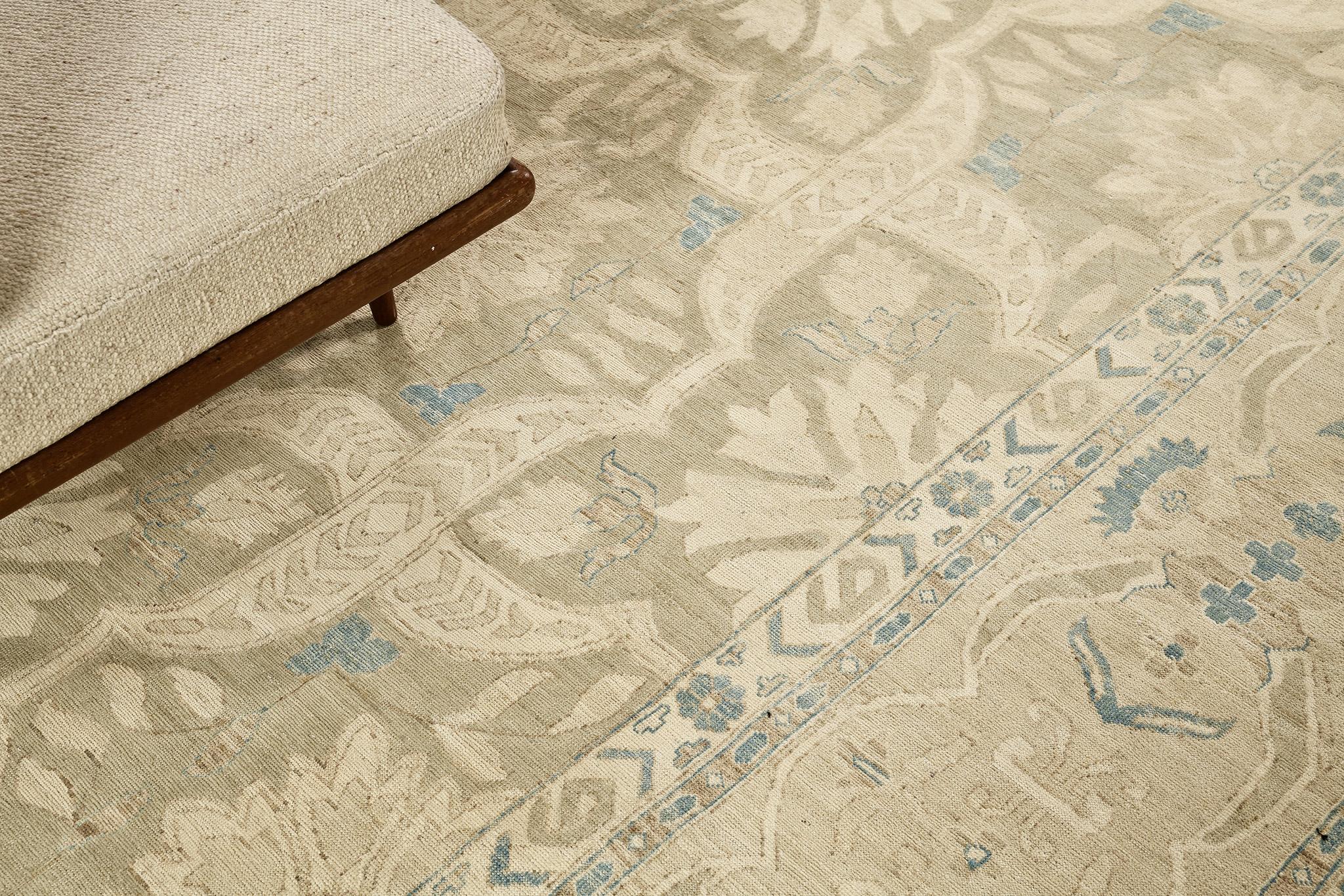 A wondrous revival of Arts and Craft Style rug that features the elegant muted tones of sand, ivory and azure blue. Laying gracefully in a sandy field, the blooming palmettes and ornate botanical patterns are formed symmetrically enclosed by classy