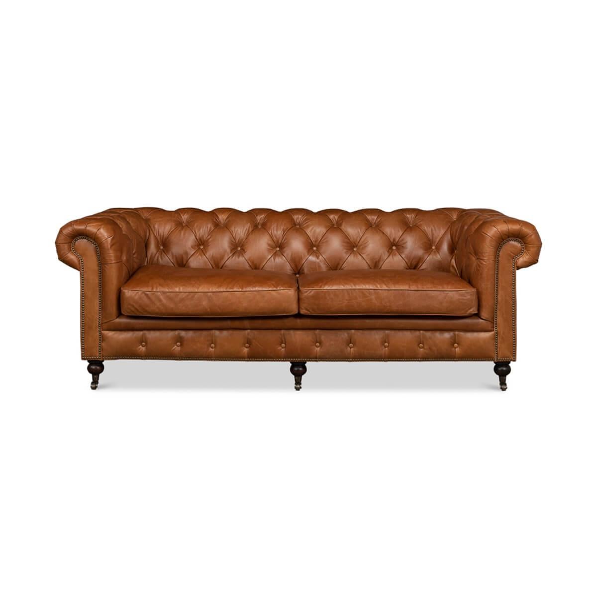 Canapé Chesterfield classique de style vintage en cuir brun de Vienne. Ce canapé traditionnel de style anglais est doté d'un intérieur capitonné, d'accoudoirs à enroulement, de garnitures en tête de clou et de pieds tournés avec des roulettes à