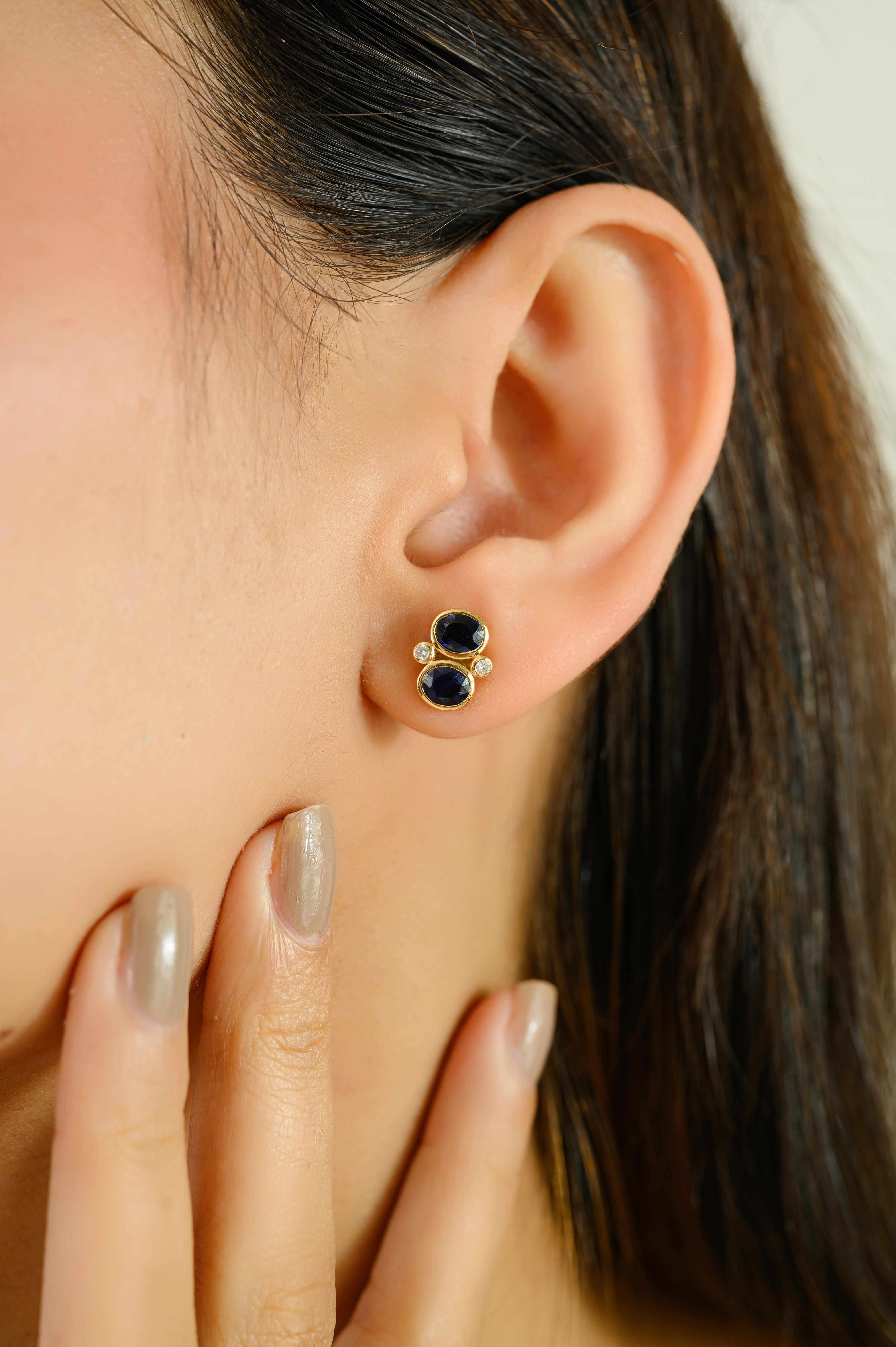 These exquisite stud earrings meticulously crafted in 14kt yellow gold. Each earring showcases two richly hued oval-cut deep blue sapphires totaling a combined stone weight of 1.63 carats, exuding timeless sophistication. Accenting the sapphires are