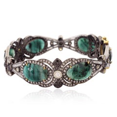 Bangle di design in stile vintage con smeraldo verde circondato da diamanti in pavé