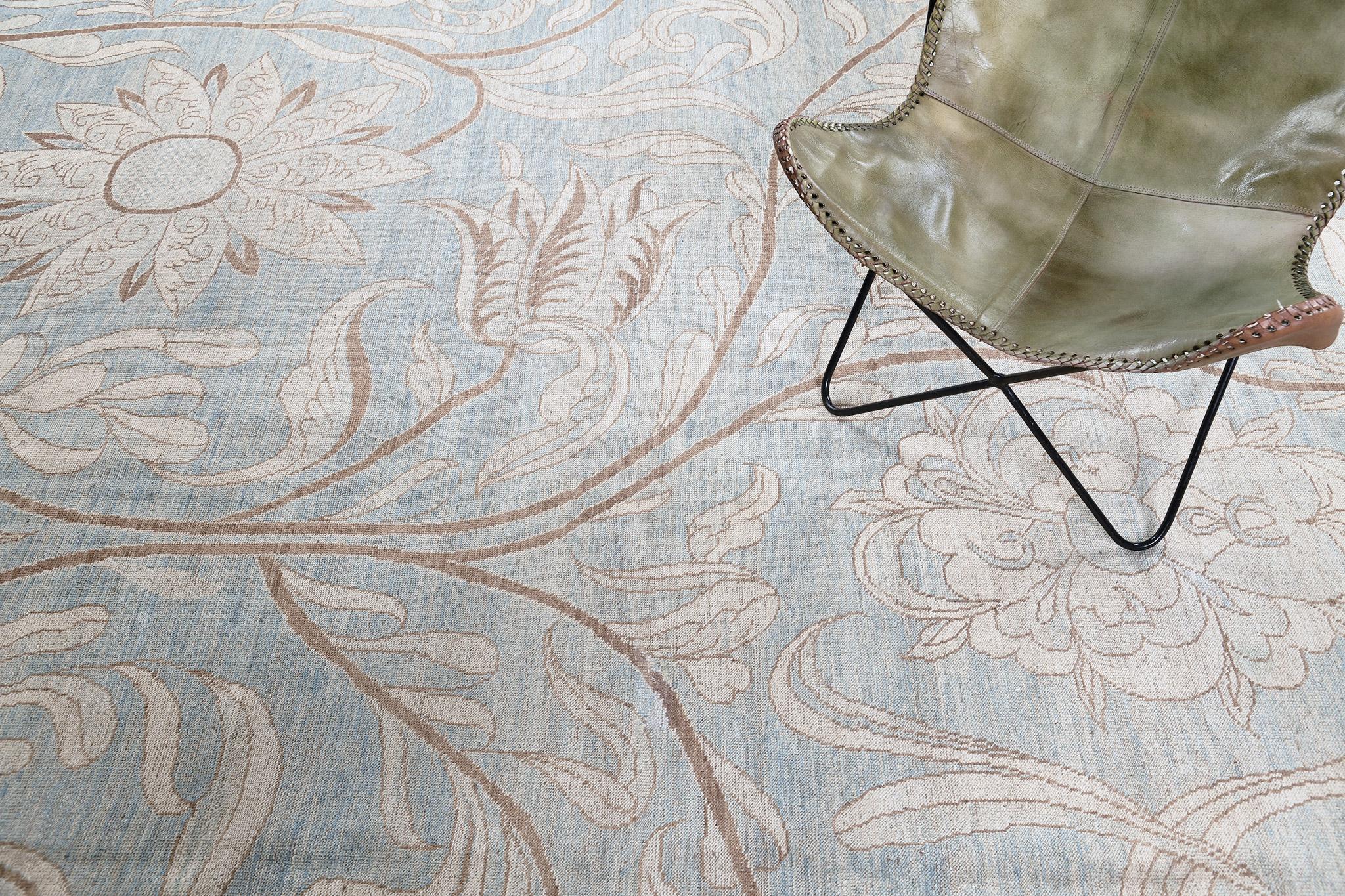 Un tappeto da sogno dal design floreale in stile vintage che mette in mostra i graziosi dettagli della sua composizione botanica su tutto il campo blu polveroso. Gli accenti dorati del gambo rendono il tappeto unico e regale. Un tappeto magnifico