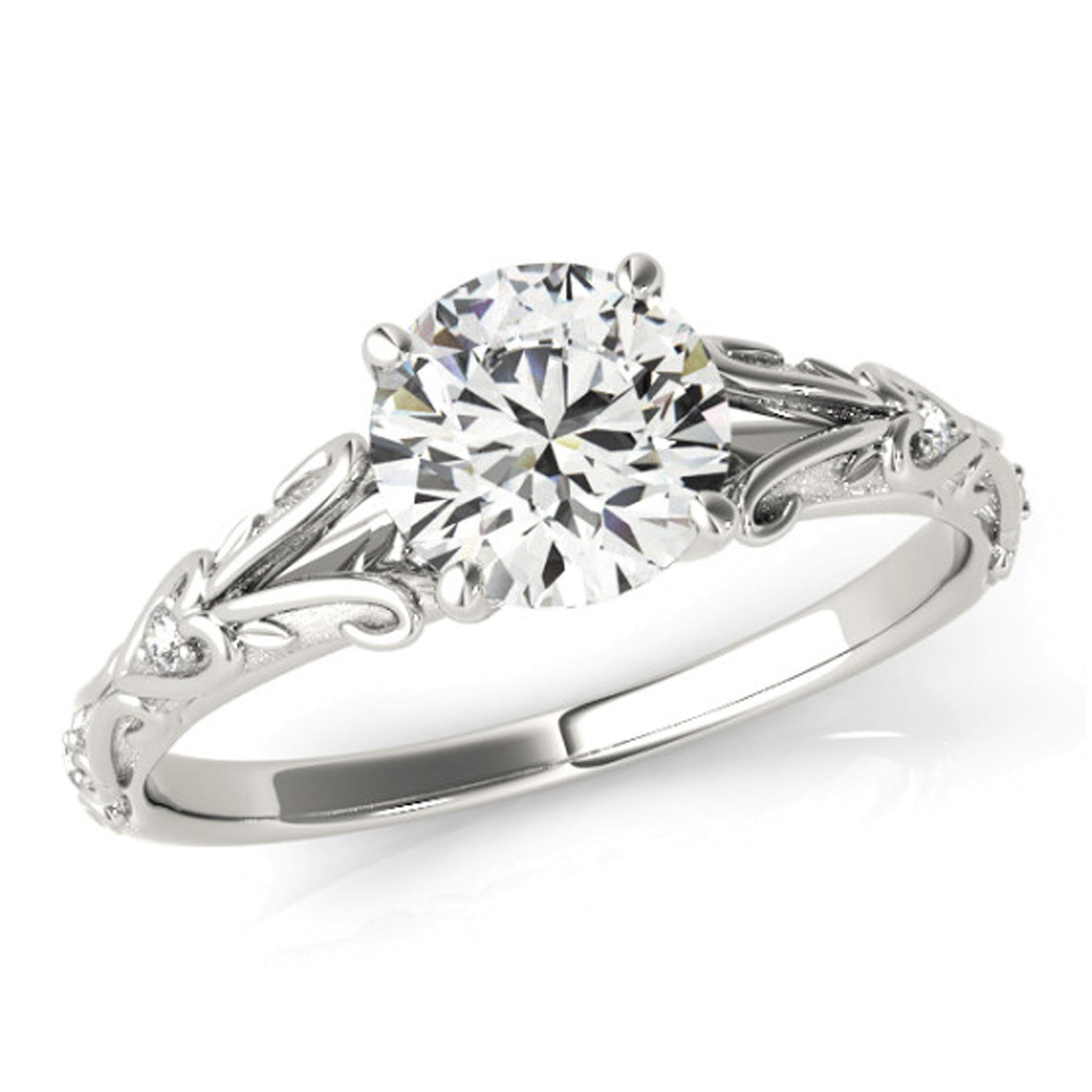 Filigree heart scrolls decorate the shank of this vintage style diamond engagement ring. Secured with prongs, the 9mm moissanite center stone shines brilliantly in the center. Handcrafted meticulously in 18k white gold, additional diamonds line the