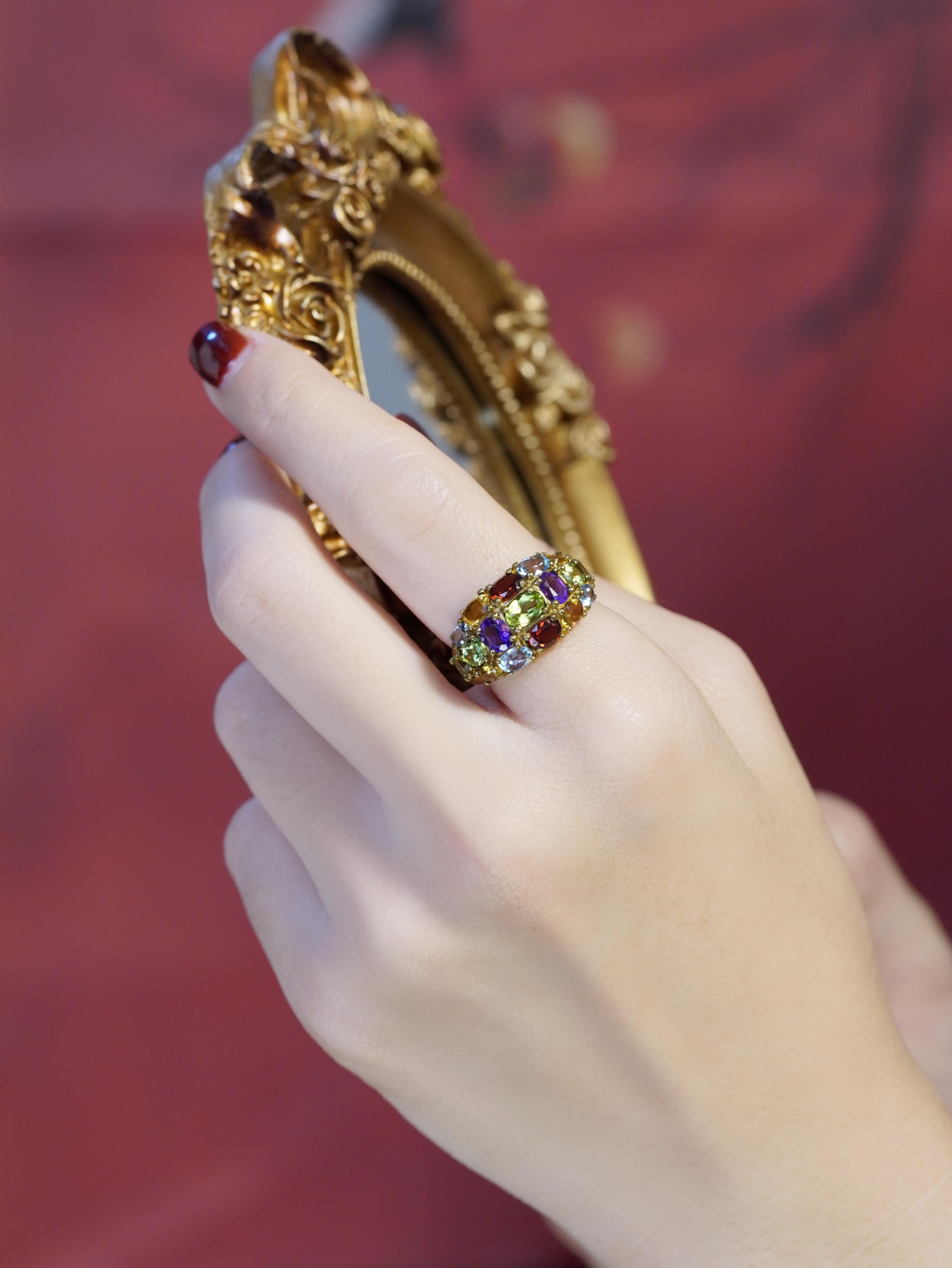 Cette bague accrocheuse présente un magnifique mélange de pierres précieuses naturelles vibrantes, serties de manière experte pour créer un éblouissant étalage de couleurs. Son design d'inspiration vintage présente des détails complexes qui lui