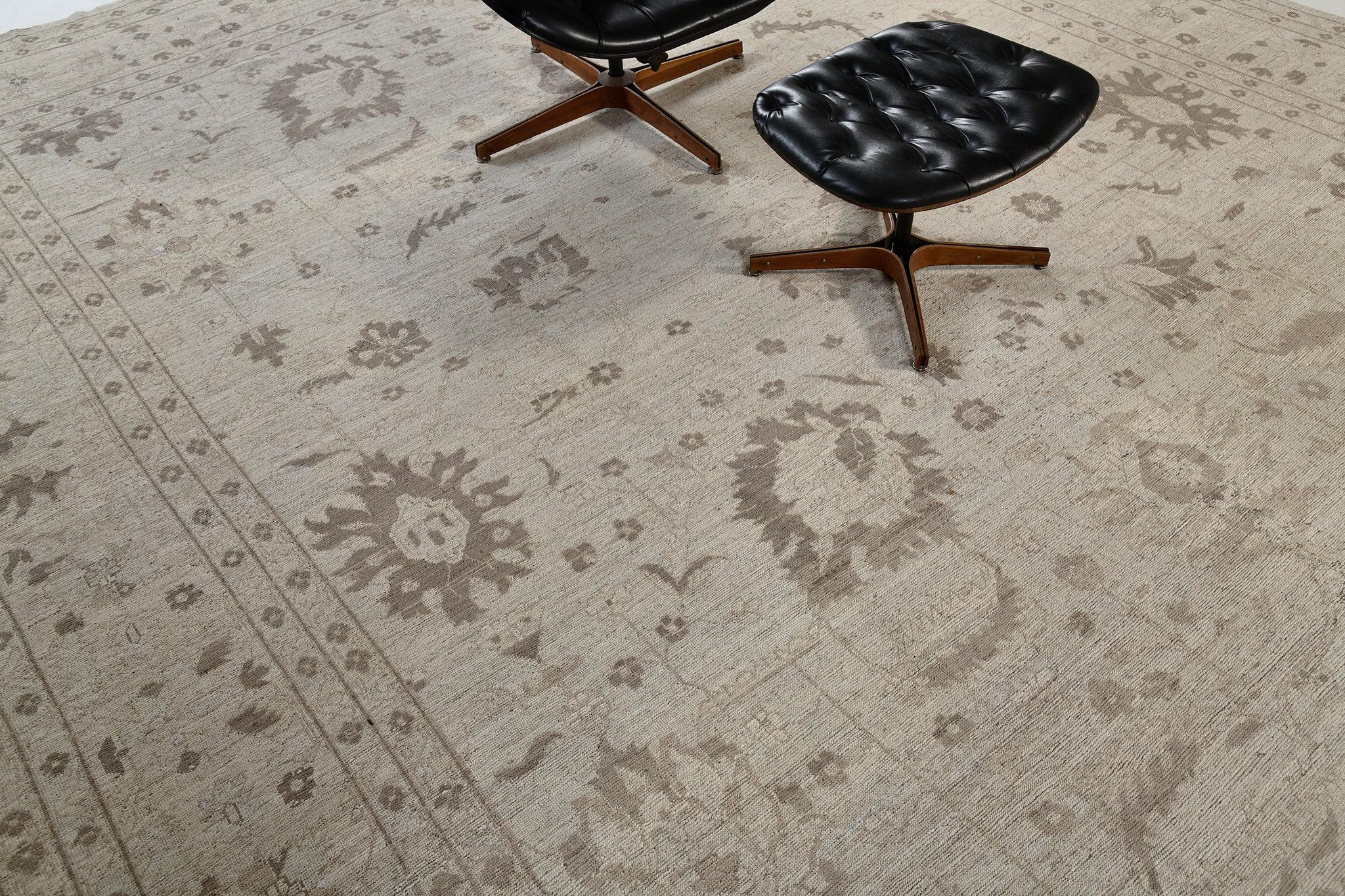 Ein stilvoller Oushak-Revival-Teppich in den kühlen Tönen von Silber und Mokka-Beige, stilisiert mit majestätischen botanischen Details. Dieser klassische, ruhige und gemütliche Teppich aus handgesponnener Wolle wird von einer ergänzenden Bordüre