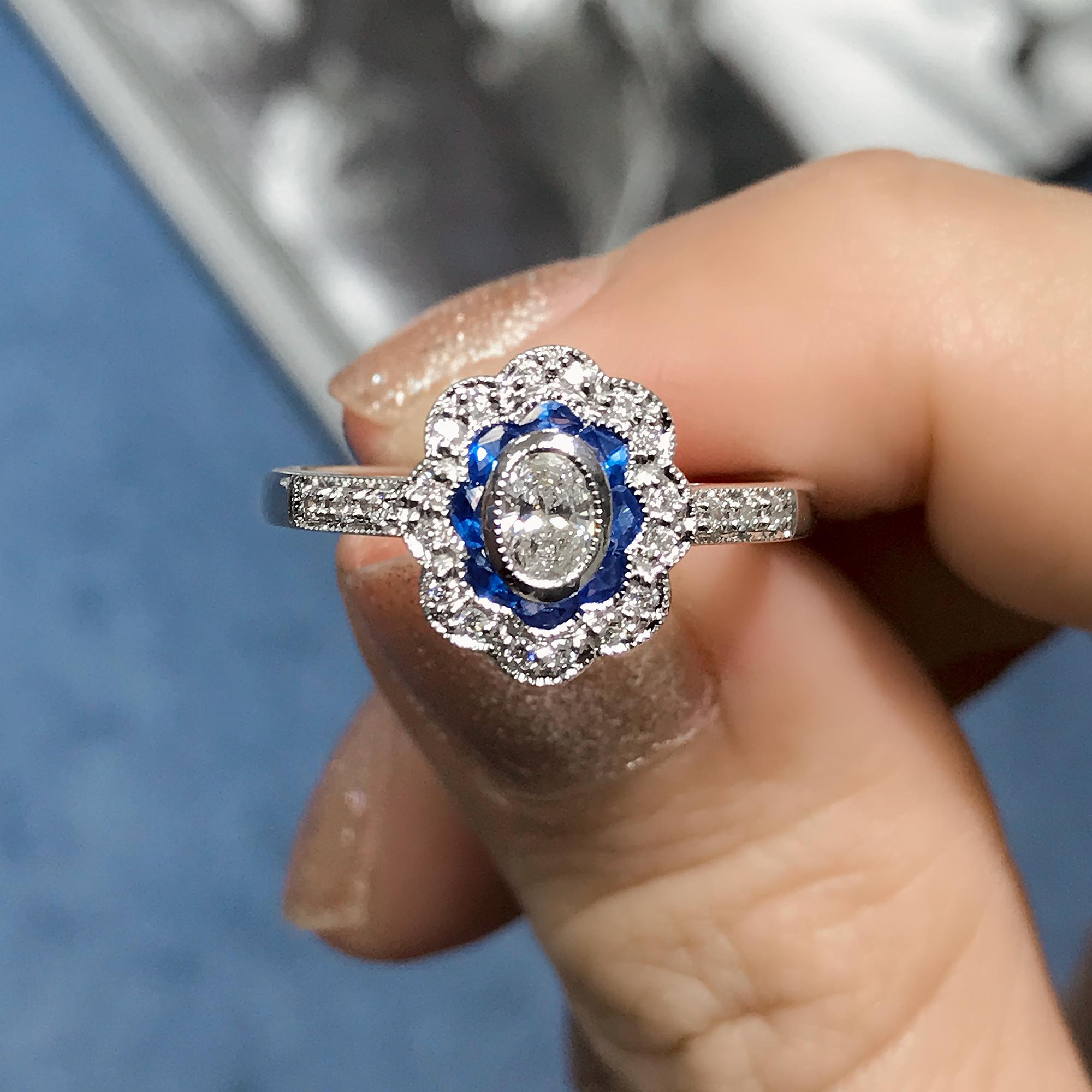 This beautiful ring is a vintage inspired style, the popular halo ring features oval G color VS clarity diamond for its center, surrounded by French cut blue sapphire and round diamonds. This would make a wonderful engagement ring, or to commemorate