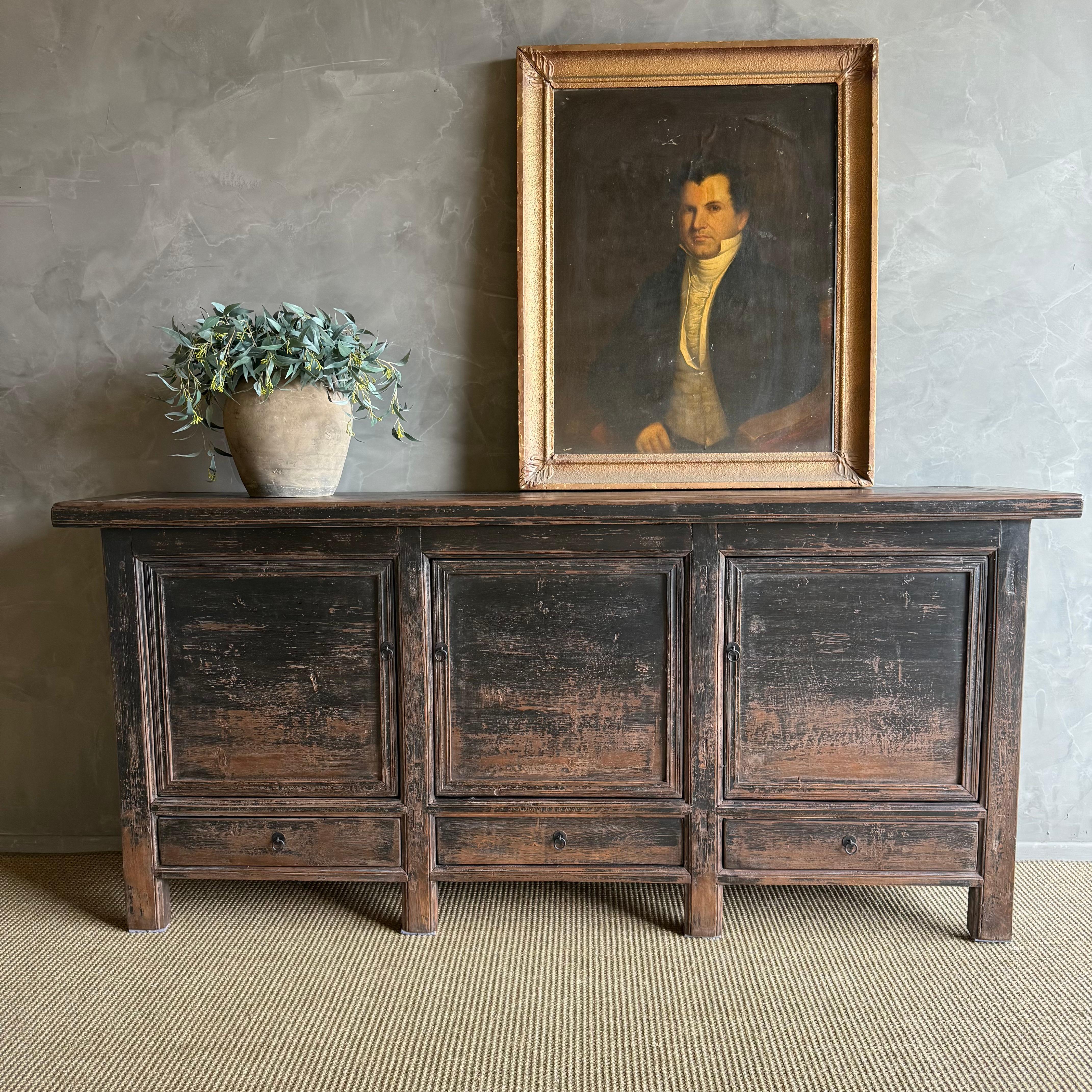 Este encantador armario vintage de madera de olmo es una pieza única en su especie, con un bello envejecimiento y pátina, que añade carácter a cualquier espacio. Su acabado de madera de olmo pintada a la pátina resalta la belleza natural de la