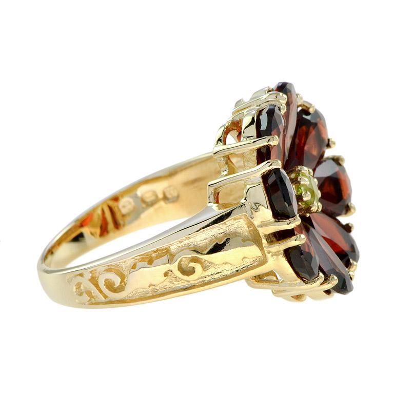 Ajoutez une touche de couleur à votre main avec cette adorable bague fleur en grenat et péridot en or jaune. Le poids total des pierres précieuses est de 8,13 carats. Il s'agit d'une bague parfaite à 9 pierres et à fleur, d'un style unique. C'est la