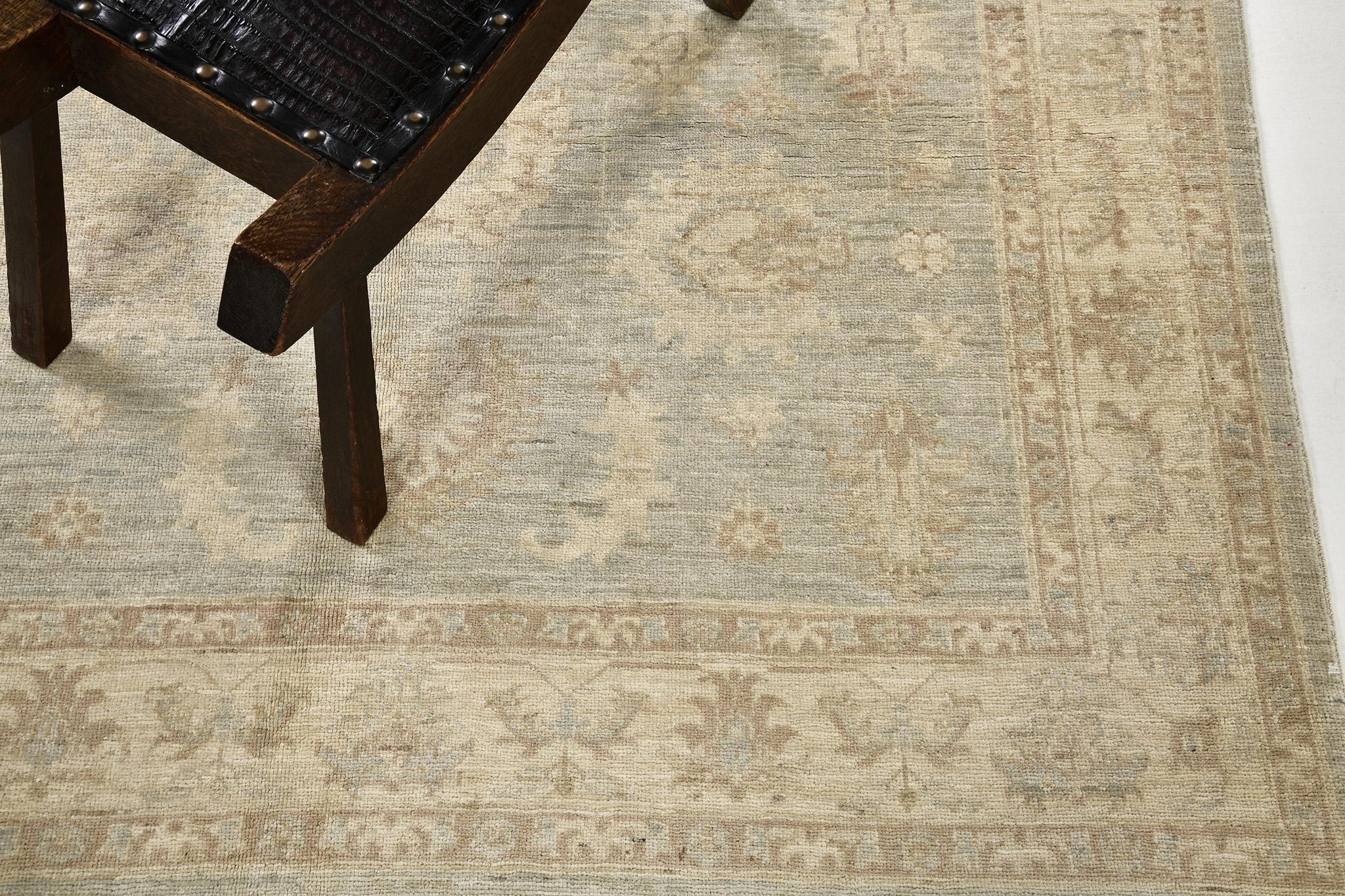 A stylish revival rug that has a mirrored pattern of an elegant floral scrolls and vine-formed medallions of umber brown and subdued ambience of skyblue with coffee brown borderlines.  This master work of art utilizes earthy and clay tones to create