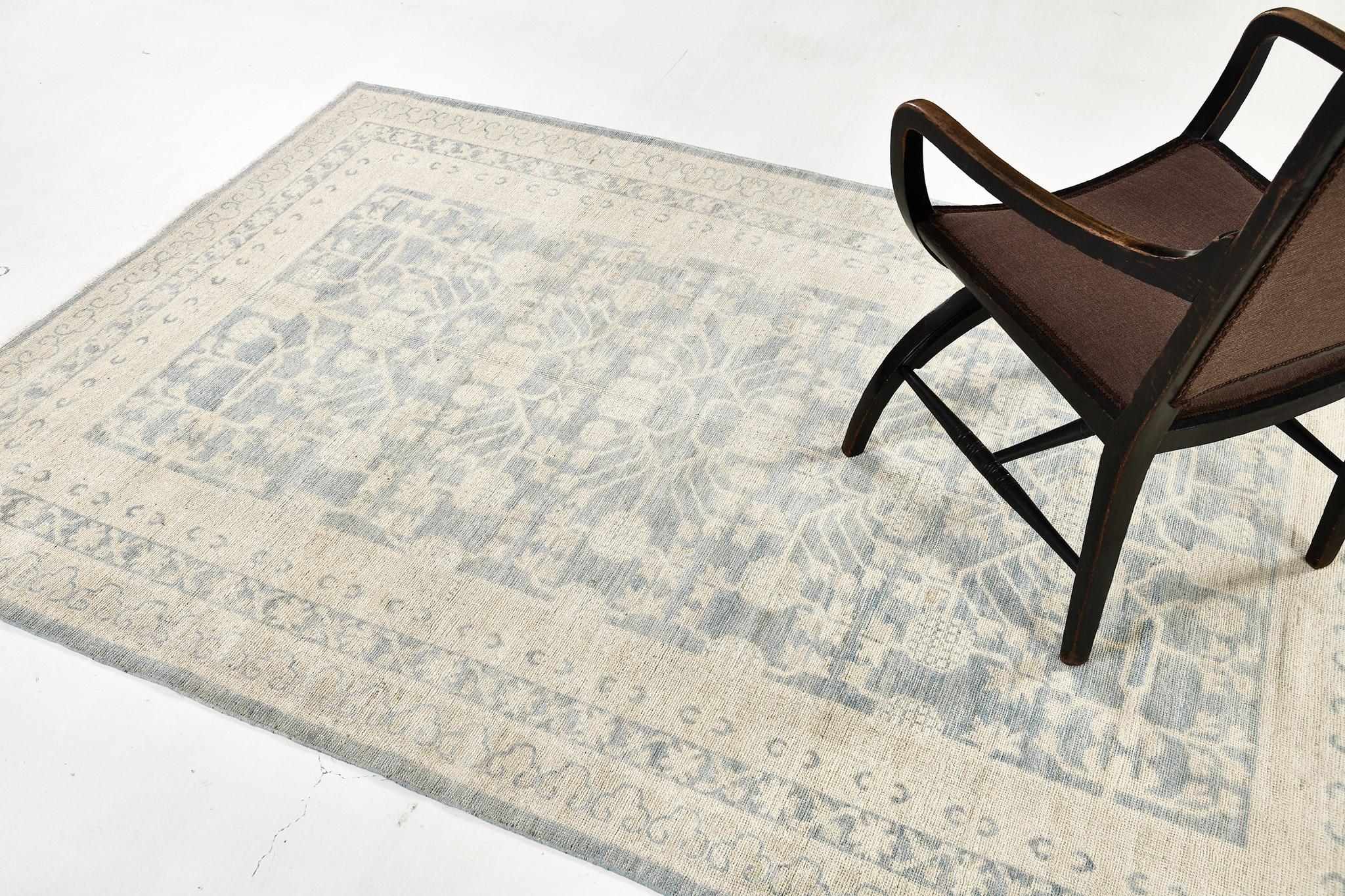 A gorgeous Khotan revival piece that showcases a symmetrical pomegranate pattern connected by a network of florid elements enclosed by Ram’s horn border. This magnificent rug exudes cozy and casual elegance with an idyllic coastal vibe featuring the