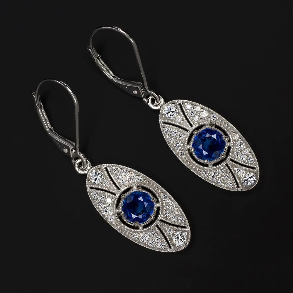  vintage style sapphire and diamond earrings have a romantic design inspired by Edwardian era touches! The oval design glitters with 0.55ct of vibrant natural diamonds which serve as the perfect backdrop for the rich blue sapphires. Graceful and