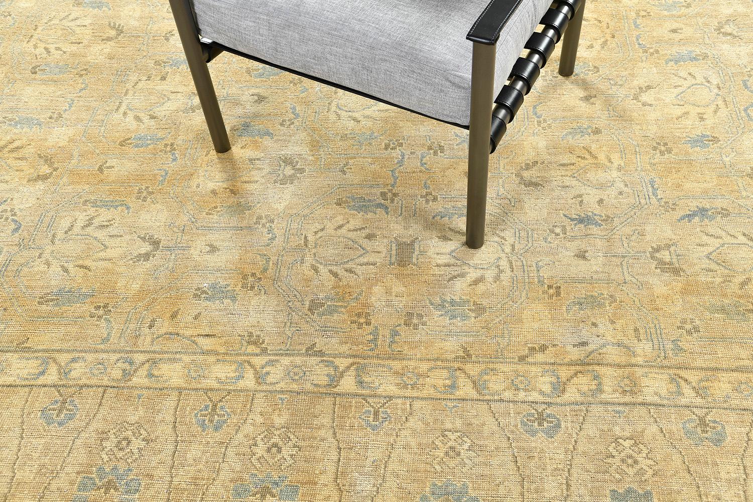 Ce tapis Shawl Design est un tapis en laine tissé à la main qui présente un élégant motif floral, des motifs géométriques et des embellissements grandioses, sur des contours dorés et gris sauge. Un motif complexe est bien coordonné avec des bordures