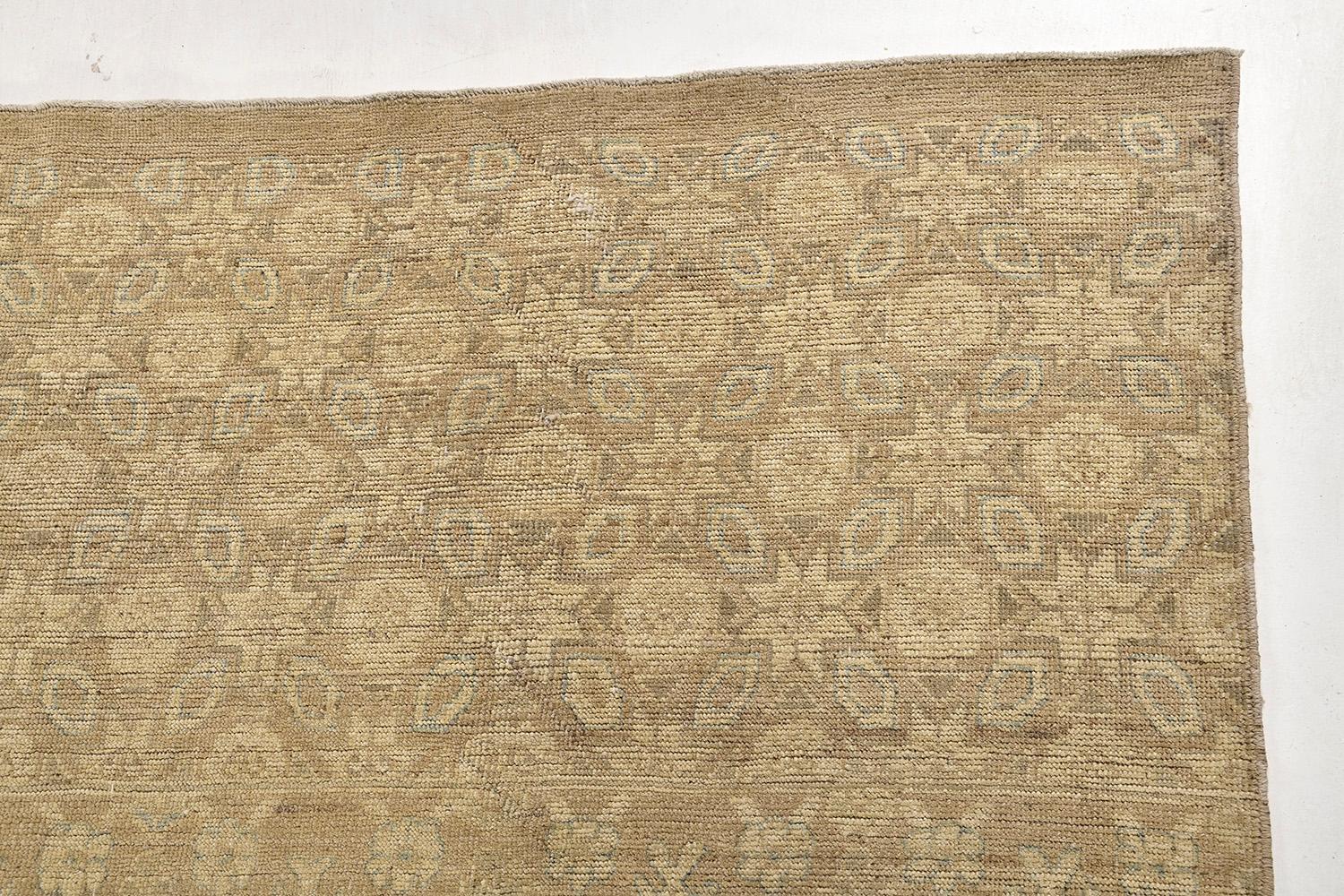 This Shawl design rug is pile-woven wool that features an elegant floral pattern, geometric motifs, and grandiose embellishments, over gold and sage gray outlines. An intricate pattern is well-coordinated with blooming borders. It is formed