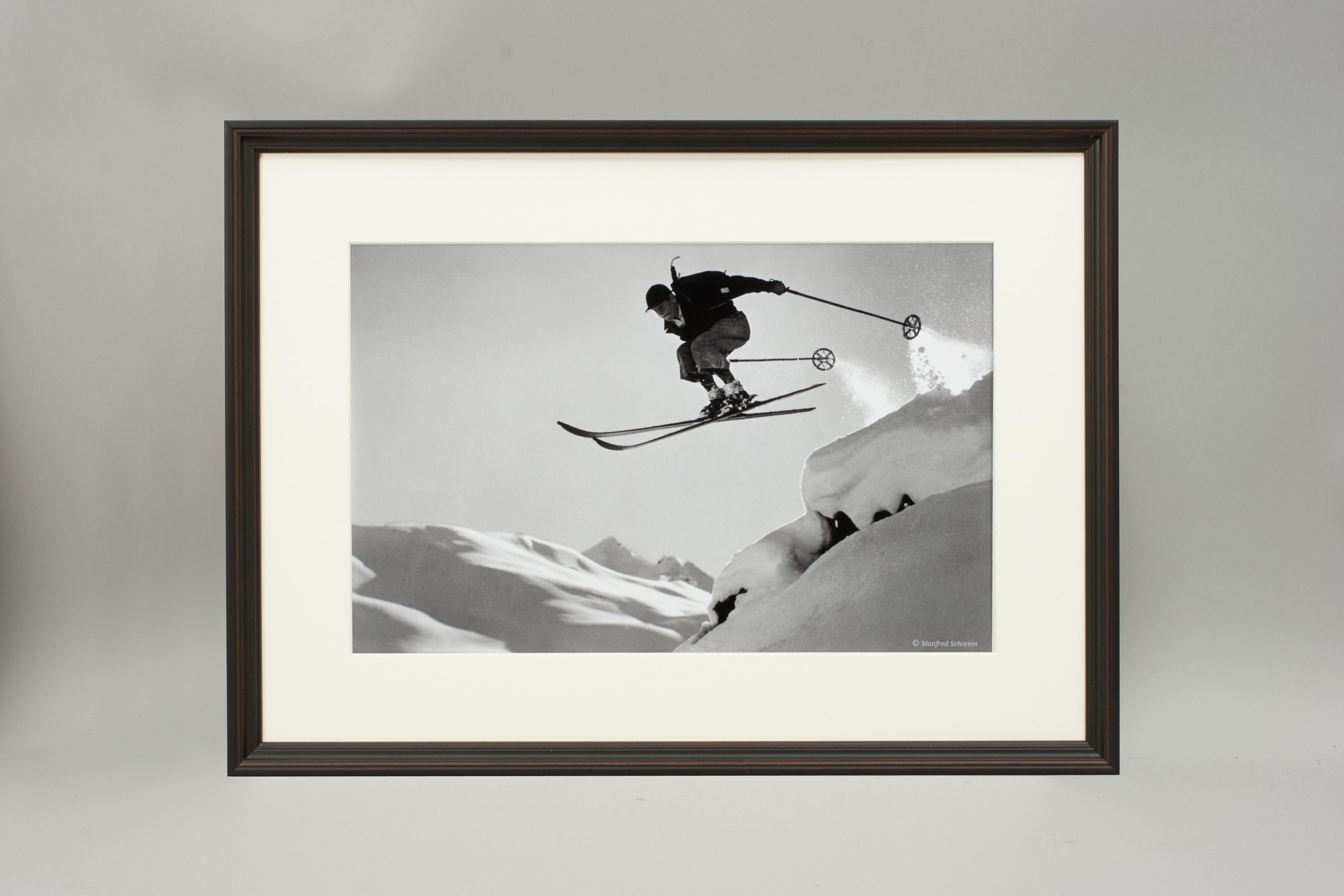 'A COURAGEOUS JUMP', a modern framed and mounted black and white photograph after an original 1930's skiing photograph. The frame is black with a burgundy undercoat, the glazing is clarity+ premium synthetic glass. Black & white alpine photos are