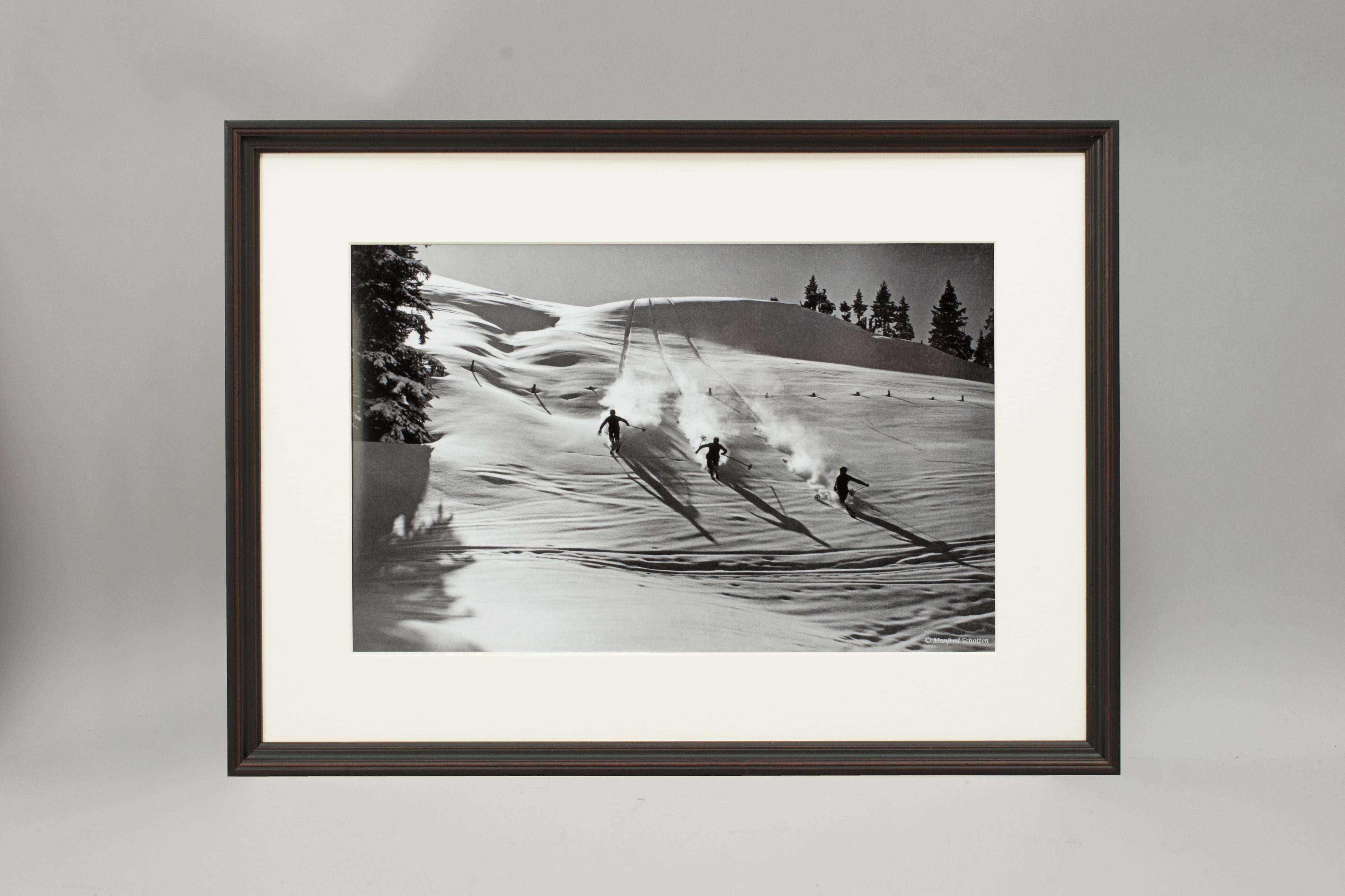 'DESCENT IN POWDER', a modern framed and mounted black and white photograph after an original 1930's skiing photograph. The frame is black with burgundy undercoat, the glazing is clarity+ premium synthetic glass. Black & white alpine photos are the