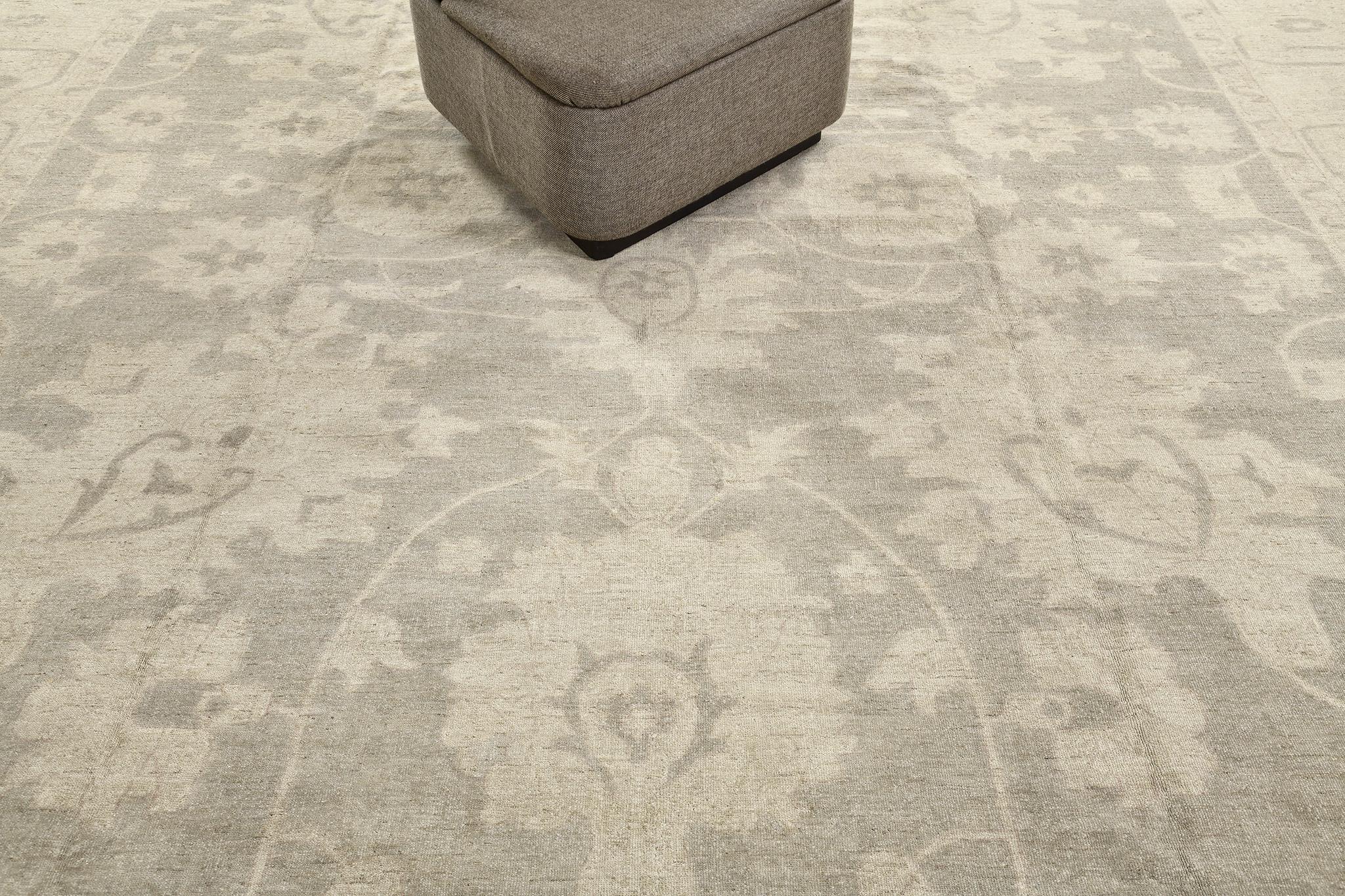 An exceptional Sultanabad revival rug that features the soothing muted tones of beige and slate gray. The large scale palmettes, stylized florals and intertwined vines are gracefully strewn into the stunning abrashed field of this elegant rug. A