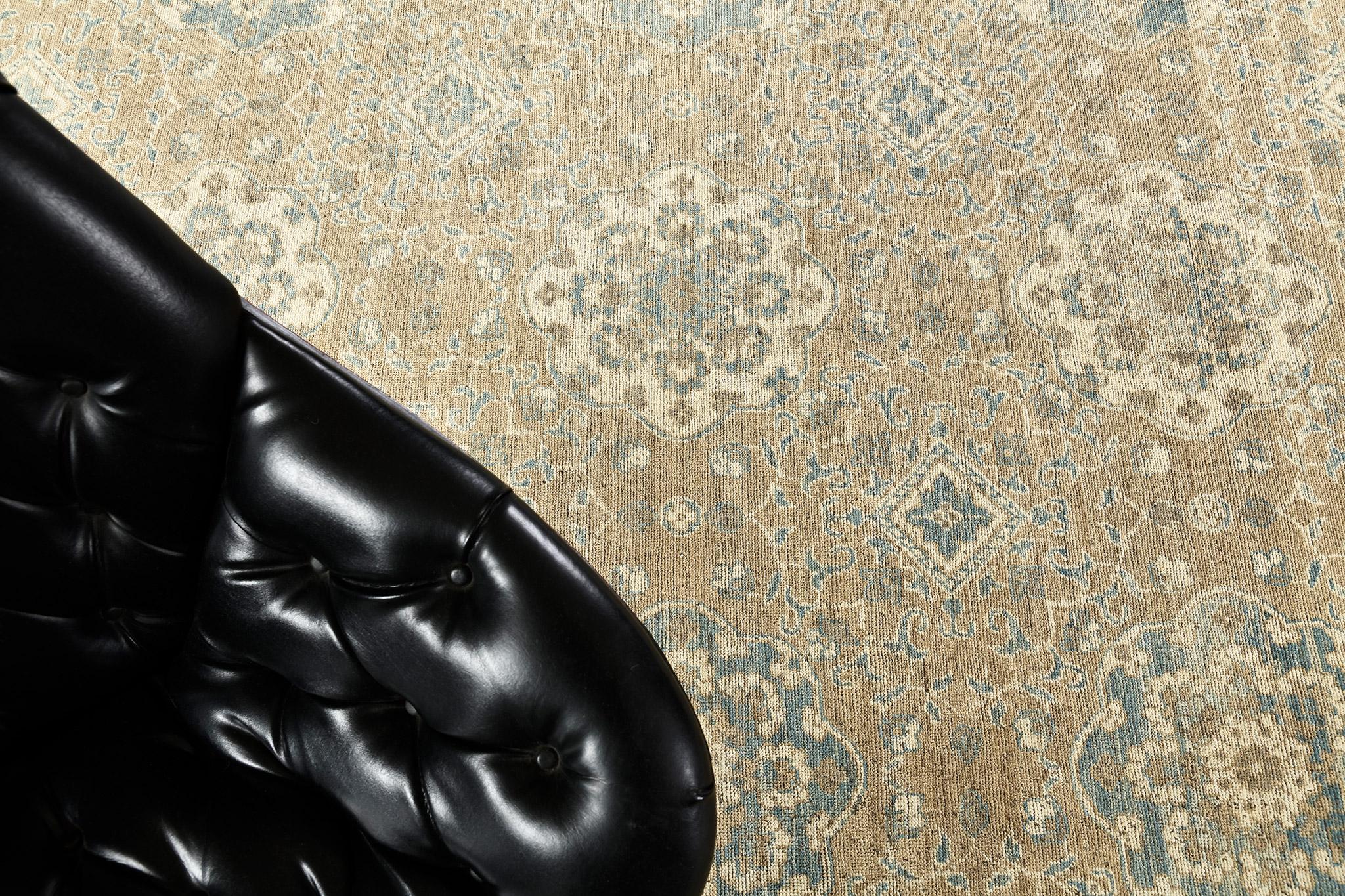 Un tapis de style transitionnel habilement tissé qui présente une magnifique palette de couleurs dans les tons de beige, bleu céruléen et ivoire. Des pétales et des fleurs florissantes sont gracieusement formés en une série d'ornements symétriques