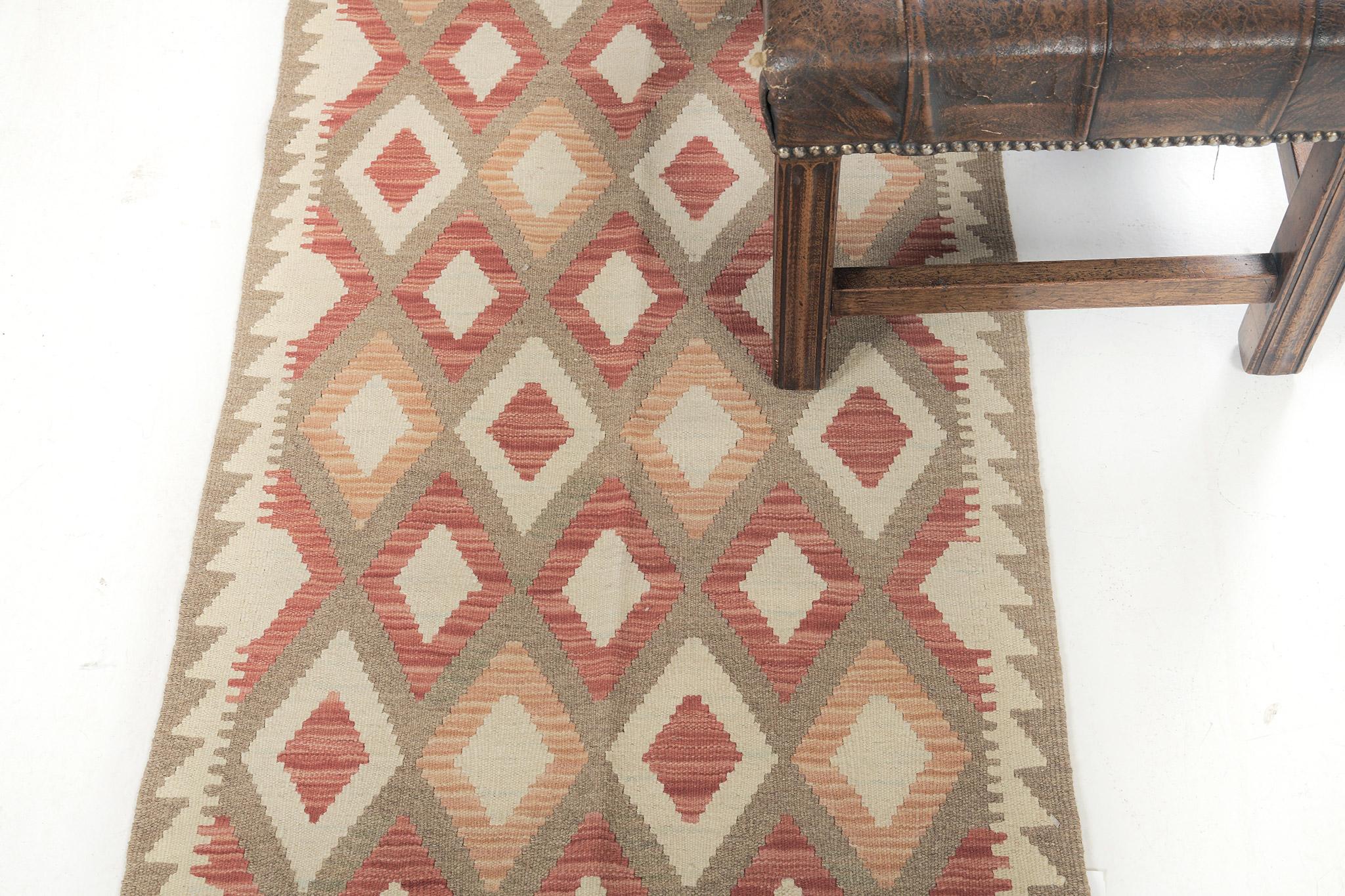A timeless vintage-styled flatweave Kilim features tribal motifs through a warm-toned palette. The multicolored diamond patterns create a joyous and charming design for a variety of interiors. This such kinds of rugs bring your room more