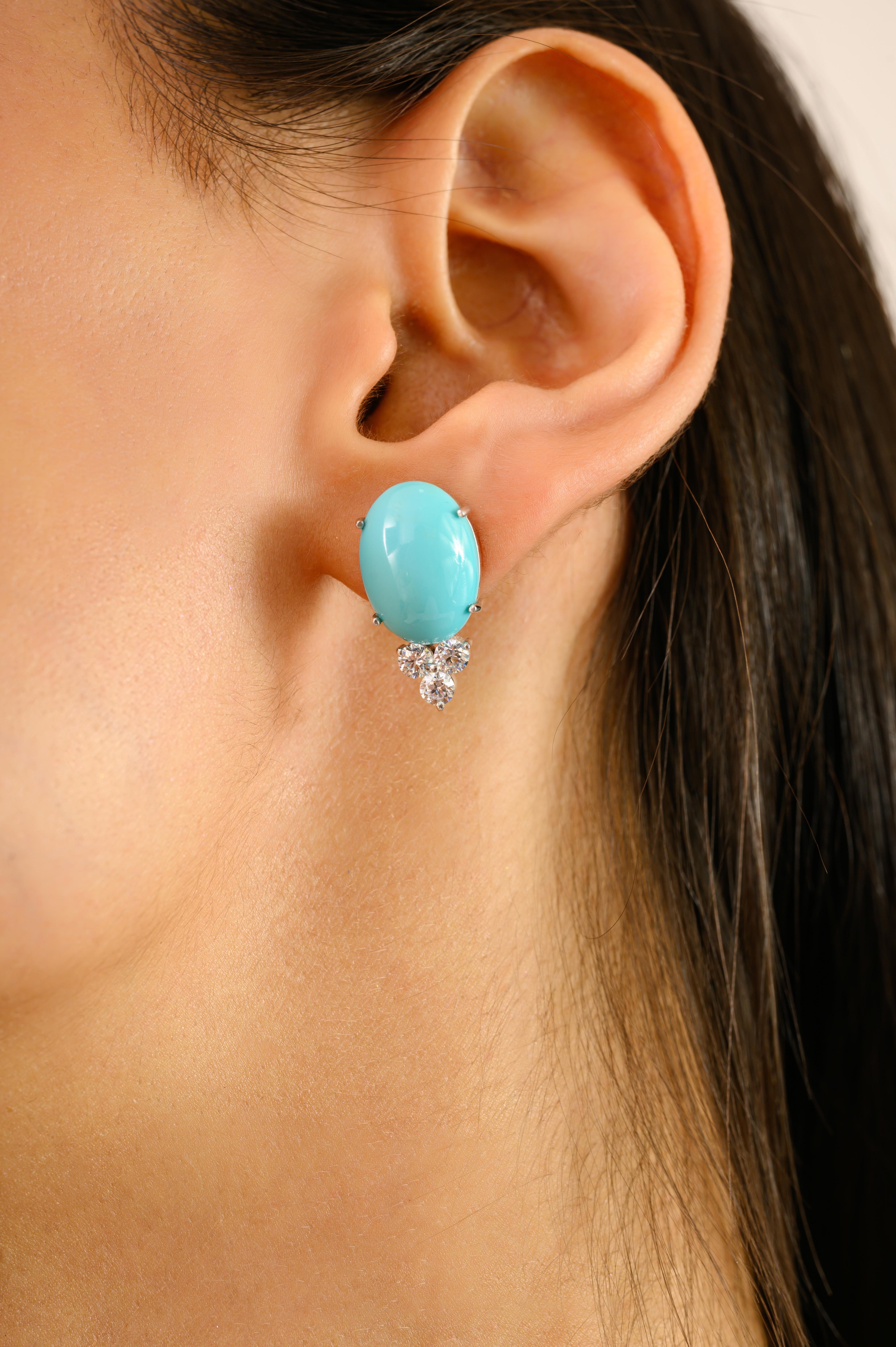 Estos llamativos pendientes con cabujón de turquesa y trío de circonitas cúbicas presentan vibrantes cabujones ovales de turquesa, elegantemente acentuados por un trío de circonitas cúbicas talla brillante en un engaste agrupado. Hecha a mano en