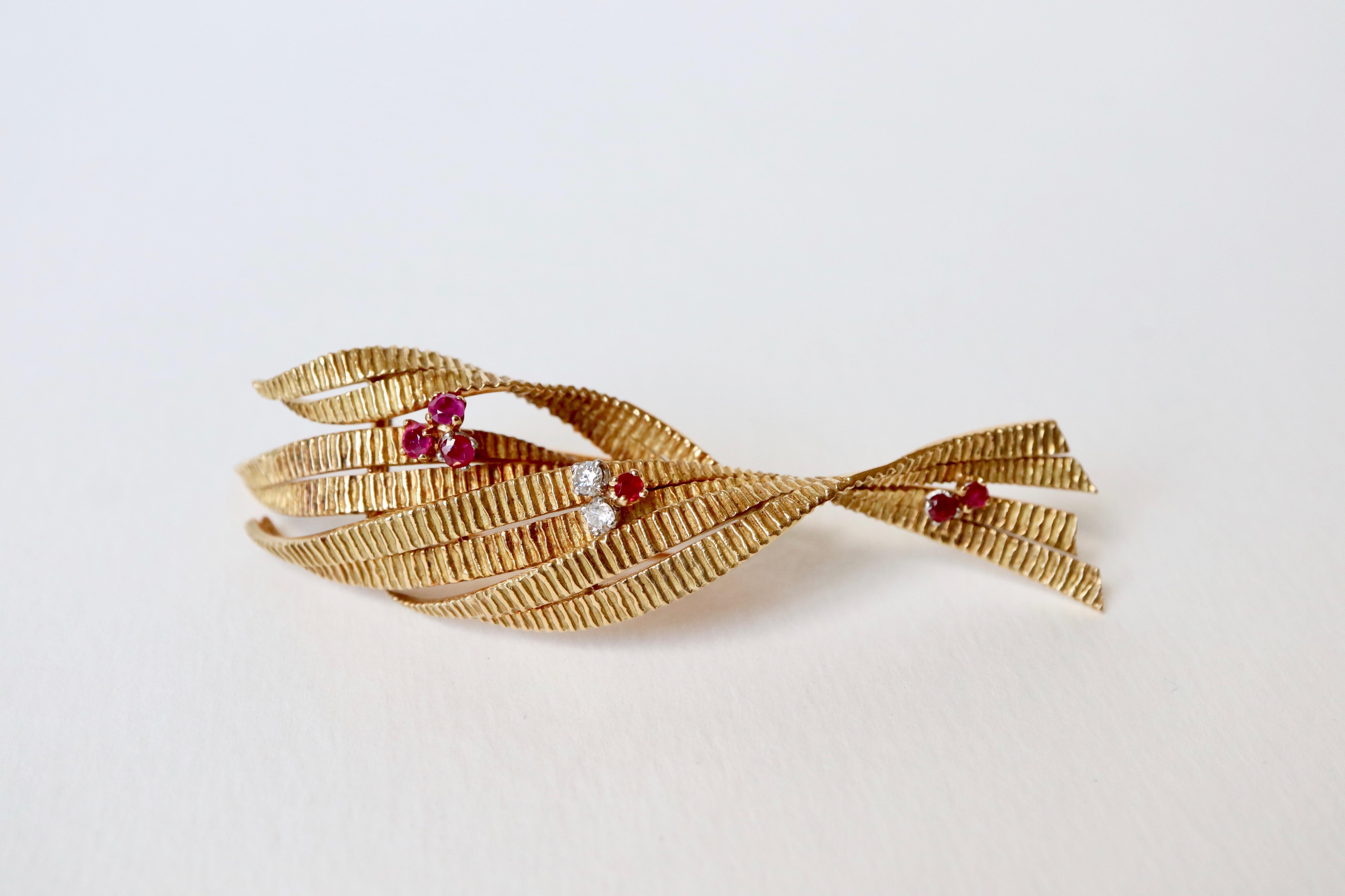 Vintage Stylized foliage brooch in 18 carats yellow gold decorated with 6 rubies and two diamonds circa 1960.
Diamonds are 0.05 carat, that is a total of approximately 0.1 carat.
Height : 8 cm Width : 2 cm 
18 Kt gold hallmark 
Gross weight: 21.4