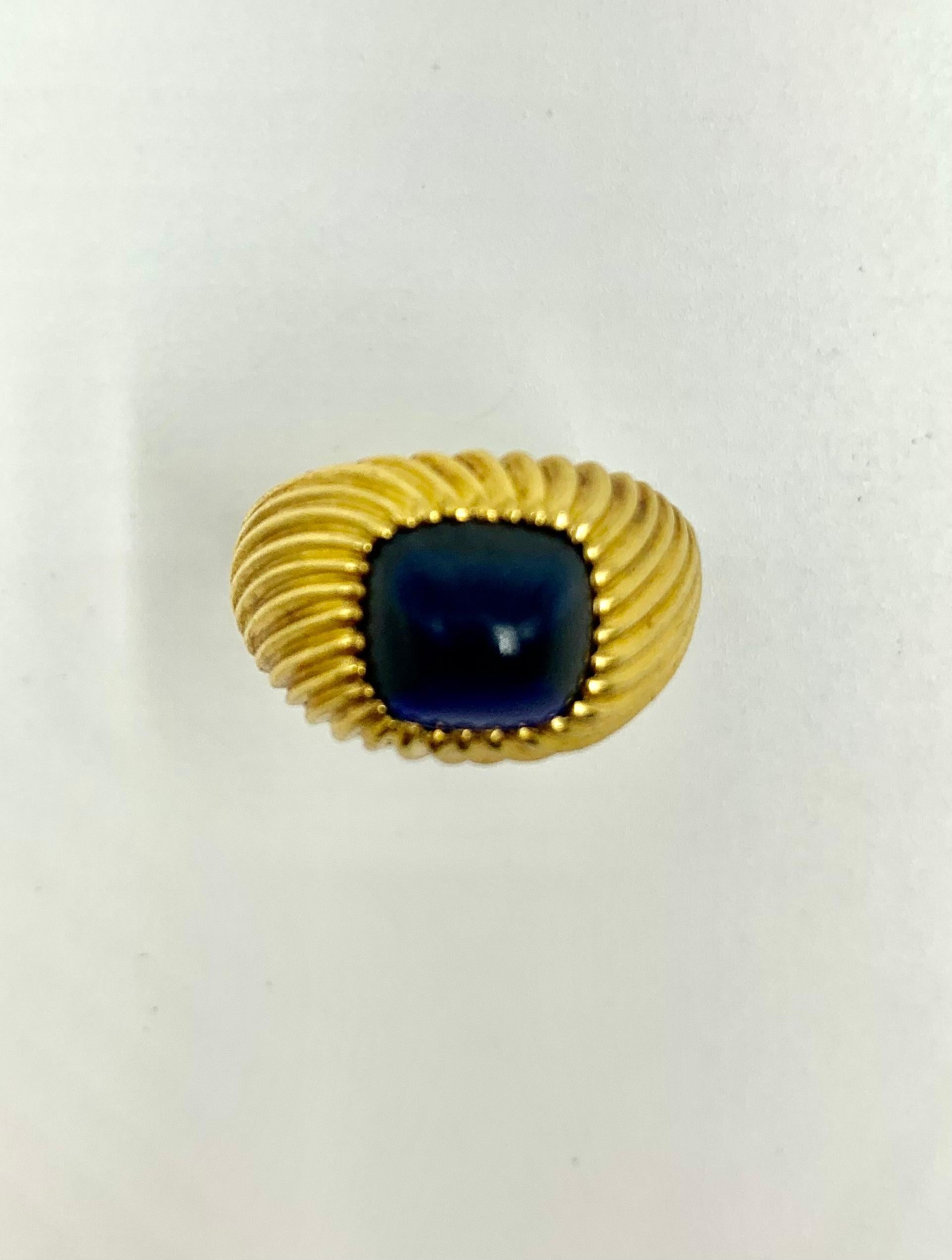 Fine vintage sapphire 18K gold ring featuring an 8mm by 8mm by 6mm, sugarloaf cabochon sapphire set in a superb tourbillon twist design setting. The gemstone showing rich, deep blue color, especially lovely in natural light, light inclusions when
