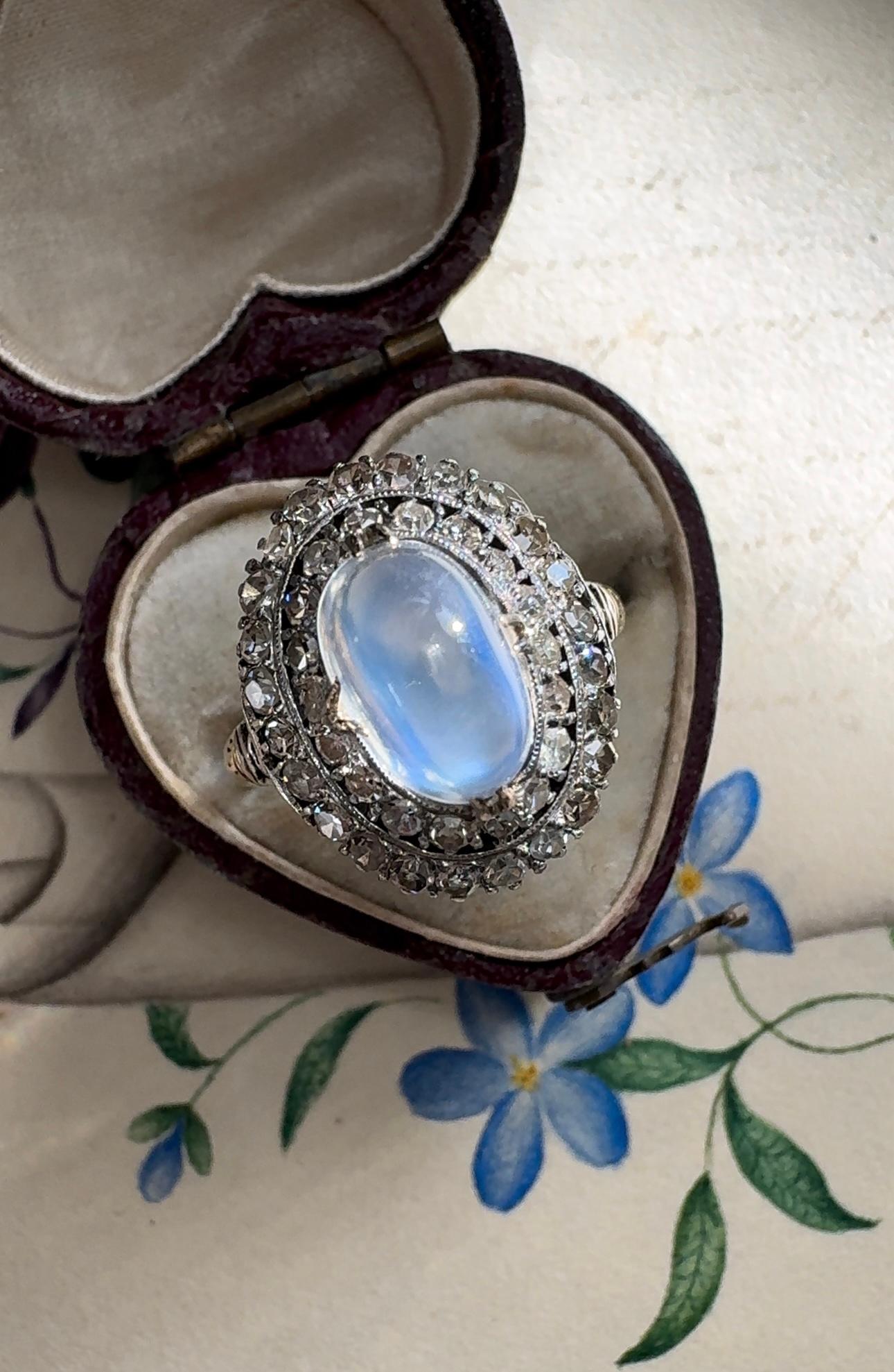 A luminous blue flash sugarloaf moonstone glows from within a stacked double halo of sparking single cut diamonds. The shoulders are perfectly adorned with delicate ivy leaves. Currently a ring size 6.

 



Measurements: 16 mm north to south, sits