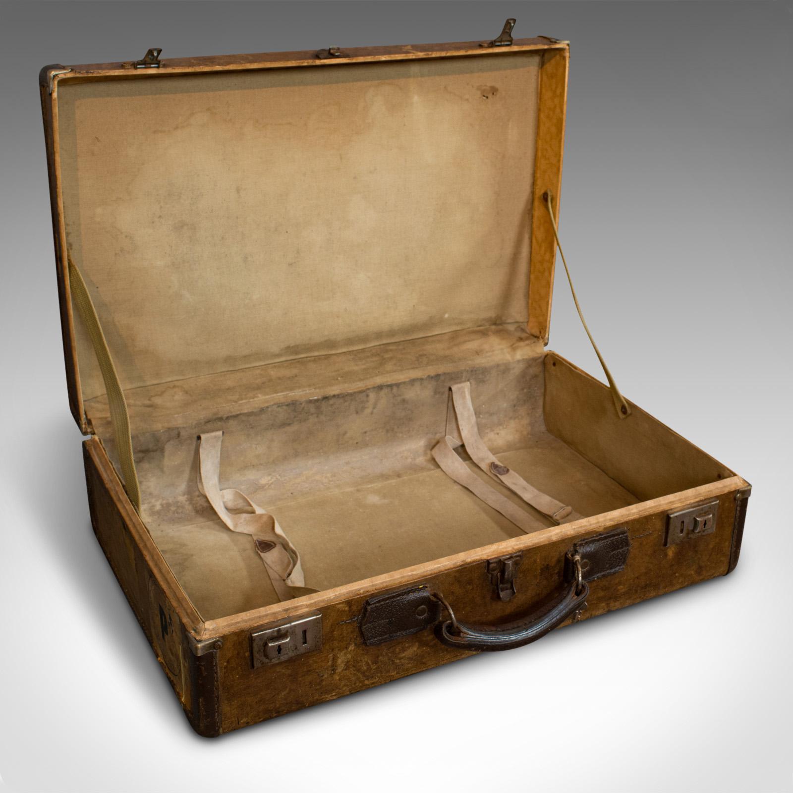 This is a vintage suitcase. An English, leather bound travel case with period decoration, dating to the early 20th century, circa 1930.

Appealing suitcase from the golden age of travel
Displays a desirable aged patina
Leather border adds tonal