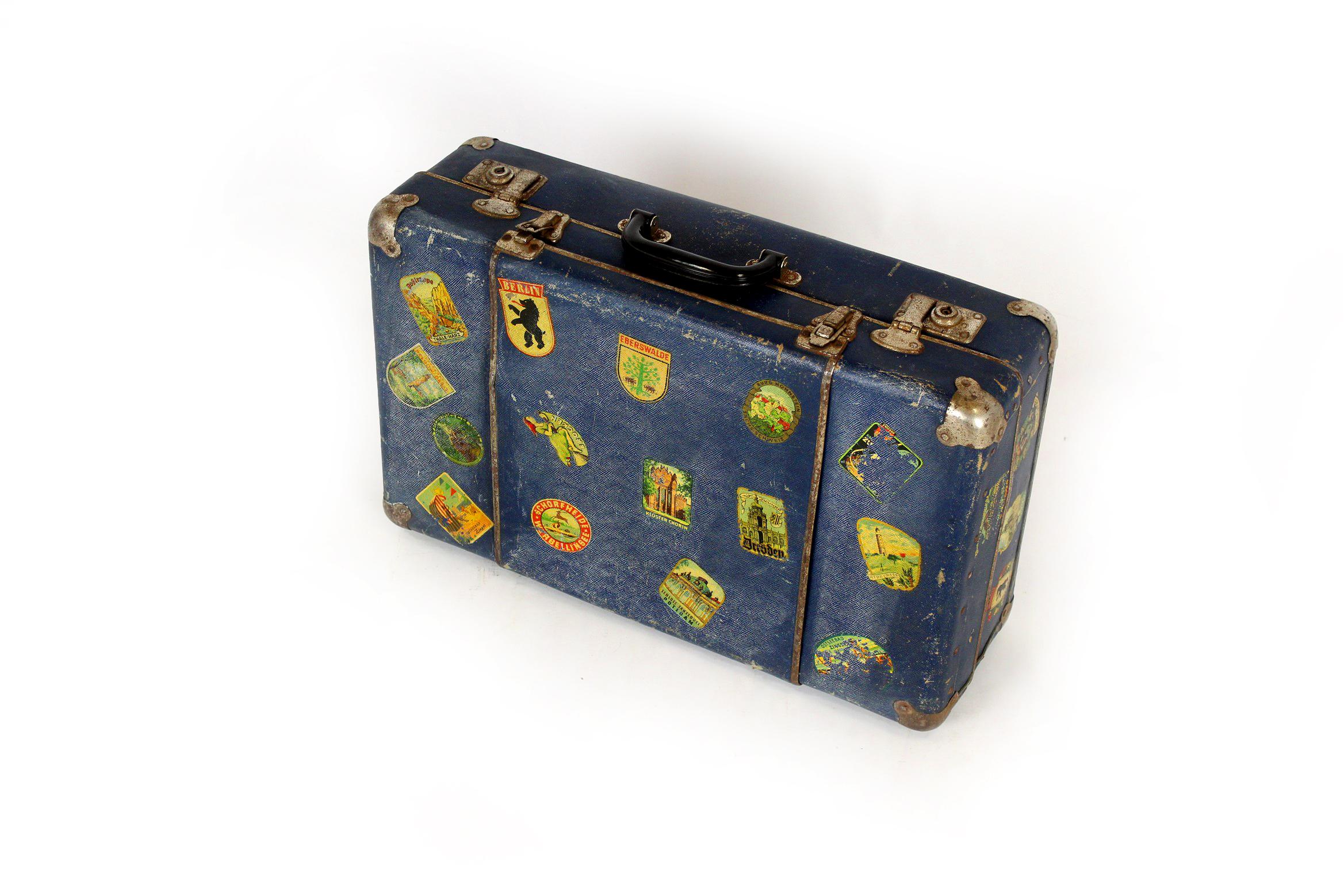 Suitcase from the 1950s, preserved in original vintage condition with visible patina. Numerous luggage labels mainly from German cities.
