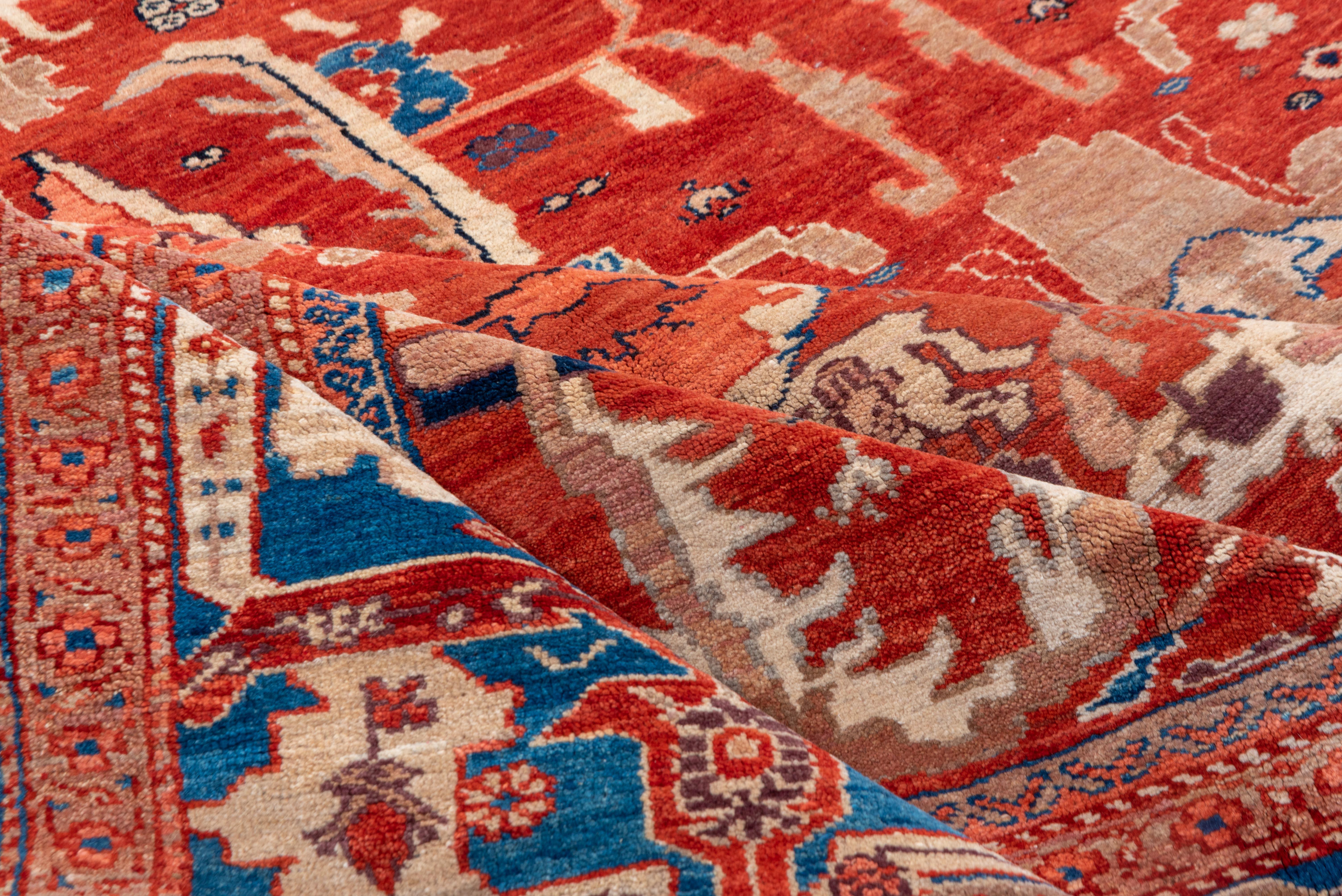 Questo tappeto vintage Sultanabad Rugs presenta un design imponente e di dimensioni eccessive con medaglioni in stile Heriz, resi in un'audace tavolozza di rosso ruggine, avorio, cobalto e rosa tenue. L'ampio campo centrale è incorniciato da un